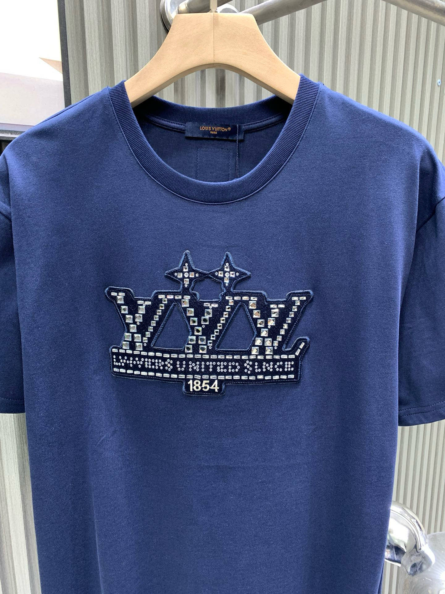 💰120🀄️   Louis Vuitton路易威登
1V 2025新款 1854钻字母棉质短袖
32支精棉平纹面料由精梳棉是经特殊工艺处理后制成其纤维更加细长且整齐
因此制成的面料在质感和耐用性上都有显著提升
纯棉材质具有优异的吸湿性  平纹面料触感柔软
穿着舒适  精梳棉的纤维结构更加紧密
因此制成的面料耐磨性更好  不易起球或变形
对花定位点缀图案  选钻是选择适合烫钻的钻石
排钻是将钻石按照设计好的图案排列在模板上
镶钻则是通过烫钻机固定在面料上
背面胶的颜色应均匀一致  且牢固度要高
结合了硅油的柔软性和弹力胶浆的高密度特性
材料具有优异的拉伸和恢复性能
在受到外力作用时能够迅速恢复原状
保持图案的完整性和清晰度