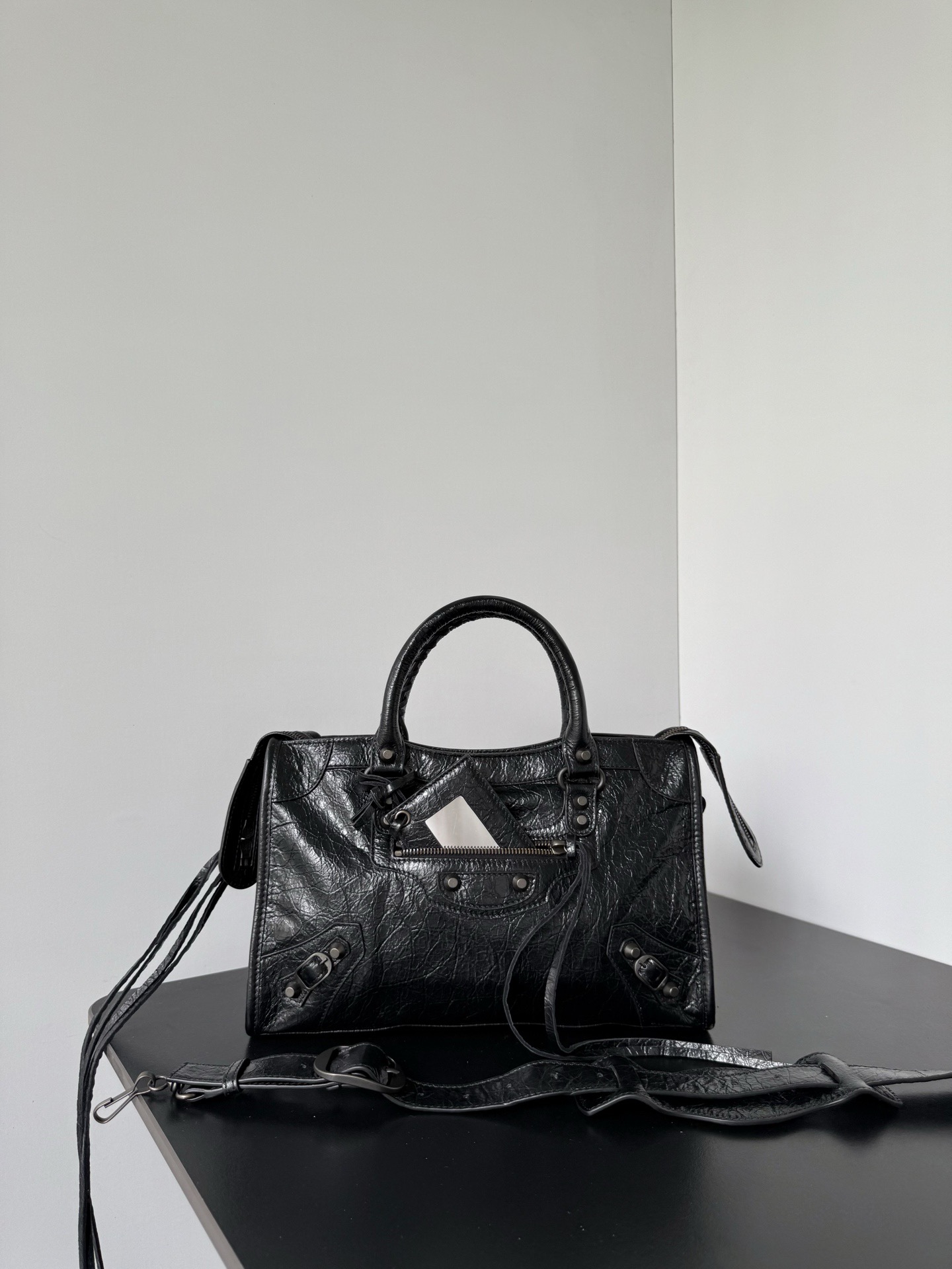 NO:894835,*  It was famous for its extremely modern style when it first came out. With its casual and natural elegance, it quickly captured the favor of the fashion industry and celebrity circles, and became a popular classic of the times. After years of reinterpretation, this new iteration of the classic handbag is the symbol of the classic style.  All the unique design details are retained, including the hand-woven cotton rope-woven leather rolled handles, detachable shoulder straps with shoulder pads, leather-edged rectangular hanging mirrors, etc. The body of the bag also retains the brand's highly recognizable rivet-shaped studs, leather lace-up zipper pullers and small decorative buckles.  Dimensions length 29.9 x height 19.1 x width 9.9 cm Model 865762 black, Balenciaga, balenciaga19860909* 初次问世便以极繁摩登的风格闻名凭借随性天成的优雅格调迅速俘获时尚界与名流圈层的青睐,一跃成为时代经典爆款历经多年焕新演绎,这款经典手袋的全新迭代版本经典款式的标志性设计细节得以悉数保留手工棉绳编织的皮革卷形提手、带肩垫的可拆卸肩带、皮革包边的长方形悬挂镜等,包身亦保留了品牌辨识度极高的铆钉形饰钉、皮革系带拉链头与小巧装饰扣 尺寸长29.9 x 高19.1 x 宽9.9厘米 型号865762黑色,巴黎世家,balenciaga,Bag