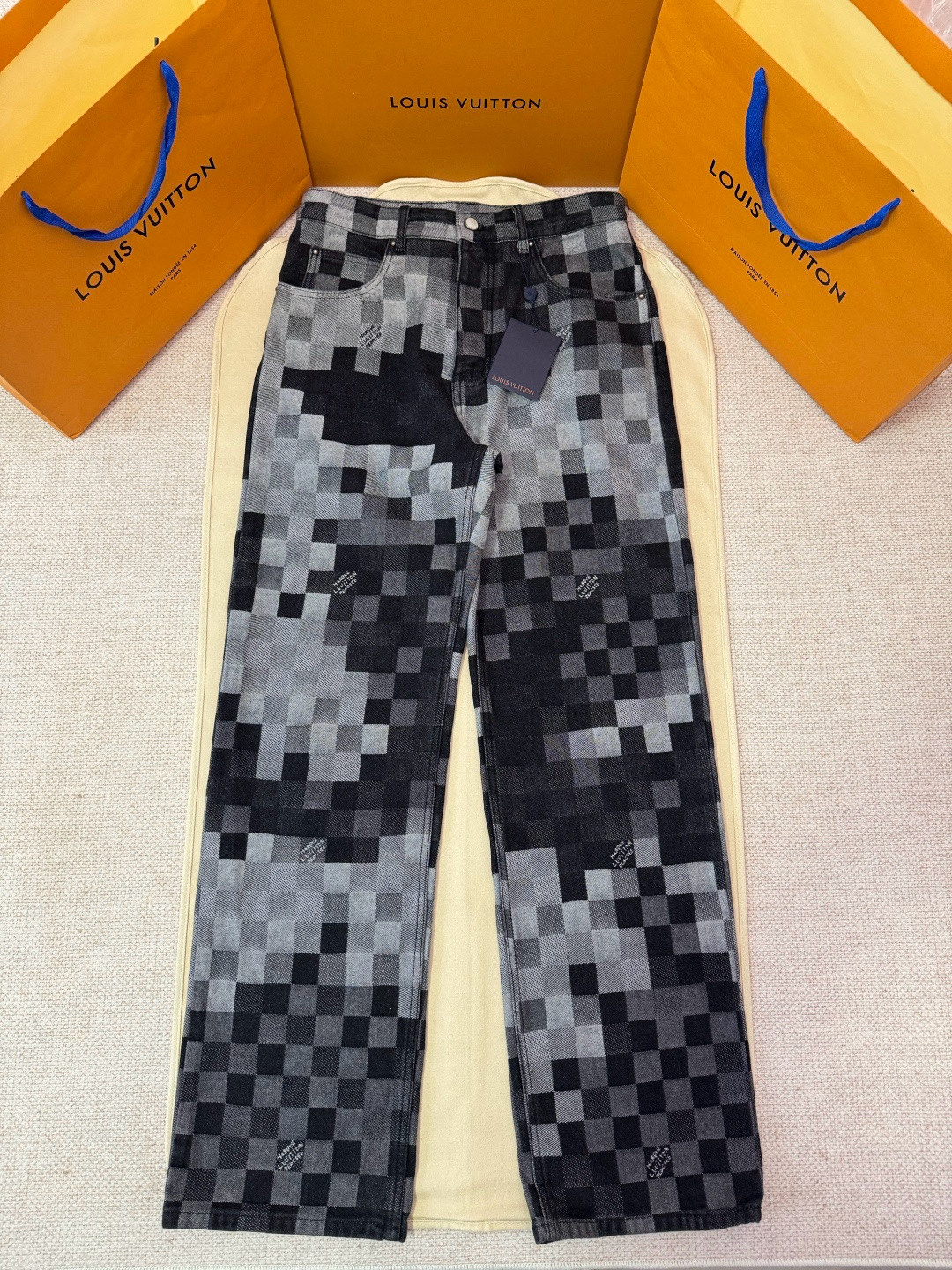 NO:702079,Exclusive original development of LOUIS VUITTON mosaic color-blocked checkerboard denim trousers. Process description. This pair of jeans from the show uses an exquisite washed jacquard damoflage pattern, showing a gradient of black tones. The jacquard process combines the classic Damoflage theme of the show with 'Marque L. Vuitton  The 'déposée' logo is cleverly woven into regular-fit denim, with some squares hiding the brand's signature. The front uses a new pearl button opening and closing design, with gem-like buttons embellished between them, and the rear is decorated with the new Damier label of the season. Through exquisite counterpoint custom sewing technology, the pattern is ensured to be perfectly connected.  Beautiful. A complete set of new accessories is available, and the same silhouettes for men and women are suitable for various body types. The washed treatment makes the denim fabric show a natural transition of blue levels. The overall design not only retains the casual feel of denim, but also shows a luxurious texture through jacquard details and metal accessories. It can be matched with items from the same series to create a complete show look.  Color black Size30/32/34/36,Louis Vuitton-clothing,louis vuitton,louis vuitton,jeans,19860909独家原版开发LOUIS VUITTON马赛克拼色棋盘格牛仔长裤 工艺说明这款出自秀场的牛仔裤采用精致的水洗提花damoflage图案,呈现渐变的黑色色调.提花工艺将秀场的经典 Damoflage主题与'Marque L. Vuitton déposée'标识巧妙编织于常规版型牛仔布中,部分方块暗藏品牌签名.前襟采用新款珍珠纽扣开合设计,宝石般的纽扣点缀其间,后部饰以当季新Damier标签.通过精湛的对位对花定制缝纫工艺,确保图案衔接完美.全套新款辅料配备齐全,男女同款的廓形适合各种体型.水洗处理使丹宁面料呈现自然过渡的蓝色层次,整体设计既保留牛仔的休闲感,又通过提花细节和金属配件展现奢华质感.可与同系列单品搭配打造完整的秀场造型. 颜色黑色 Size30/32/34/36,路易威登-服装,louis vuitton,louis vuitton,jeans,,Women's clothing
