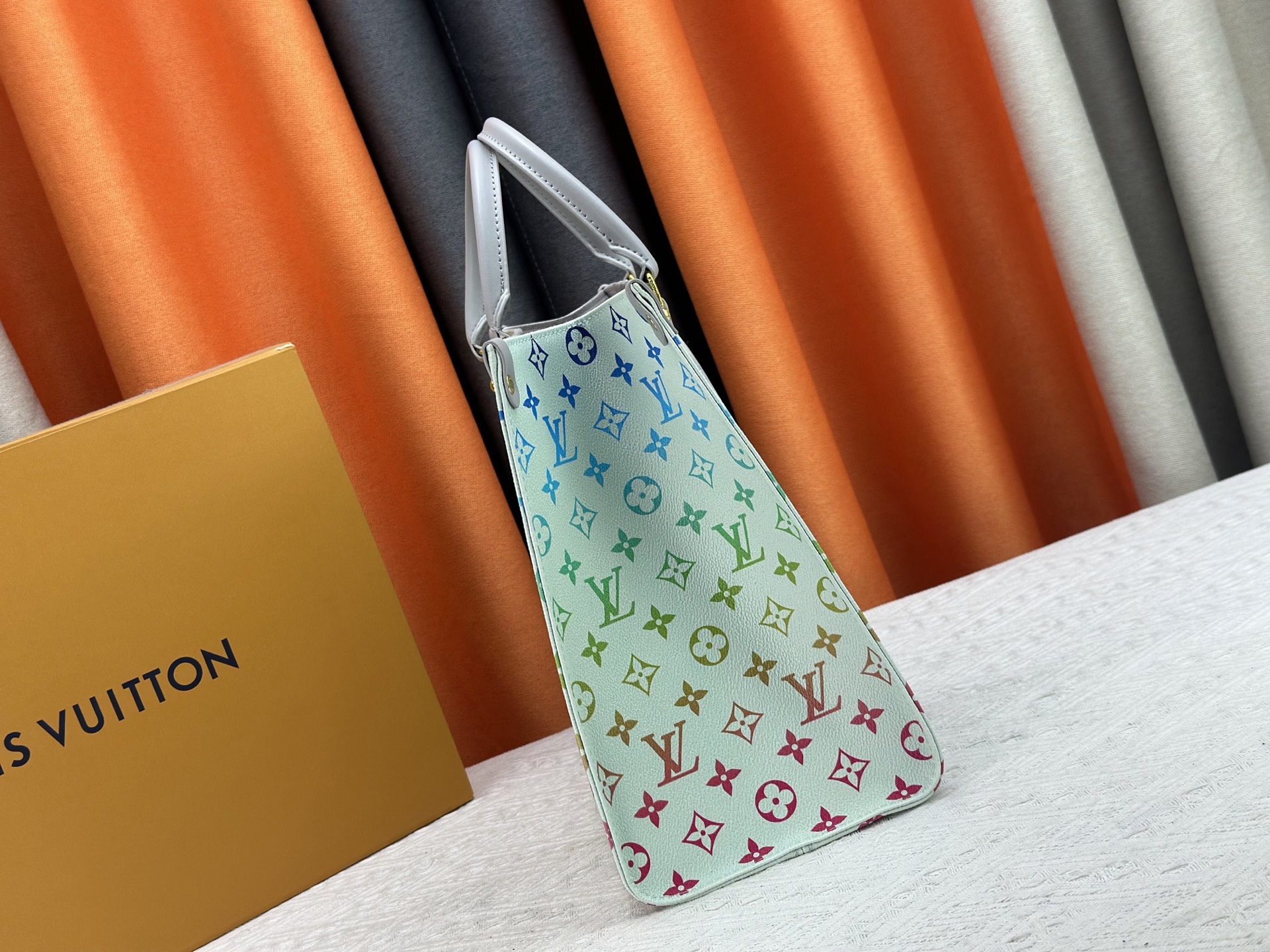 P180 2025彩虹系列，M13269,M45321.M44571.M45039本款Onthego 中号手袋将经典 Monogram 帆布与 Monogram Reverse 帆布分饰两侧，迥异风尚随心呈现。Toron 双手柄与肩带实现多种背携方式。尺寸：34.0 x 26.0 x 13.0 cm (长 x 高 x 宽).