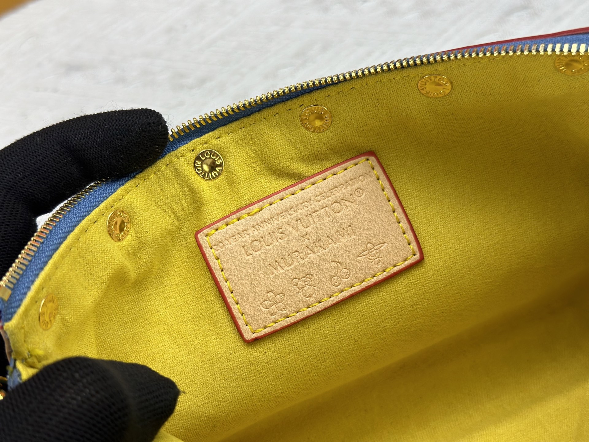 P165 M13404 丹宁牛仔本款 Pochette Accessoires 手袋取材涂层帆布，以缤纷 Monogram
图案演绎路易威登×村上隆跨界合作系列的灵动格调。牛皮革饰边和
耀目金属件点睛考究细节，可拆卸肩带和链条实现灵活背携。尺寸：22x13x4cm 