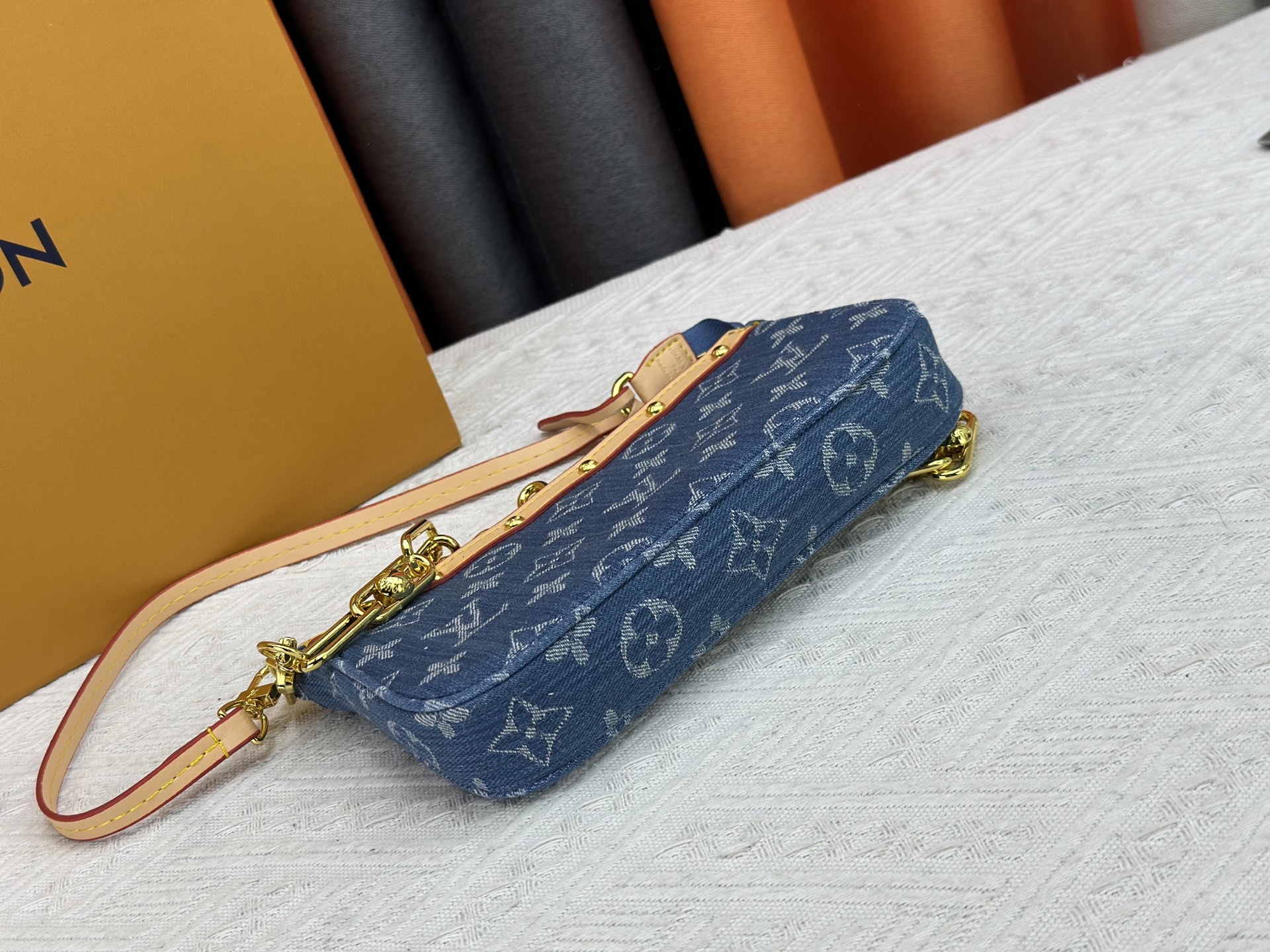 P165 M13404 丹宁牛仔本款 Pochette Accessoires 手袋取材涂层帆布，以缤纷 Monogram
图案演绎路易威登×村上隆跨界合作系列的灵动格调。牛皮革饰边和
耀目金属件点睛考究细节，可拆卸肩带和链条实现灵活背携。尺寸：22x13x4cm 