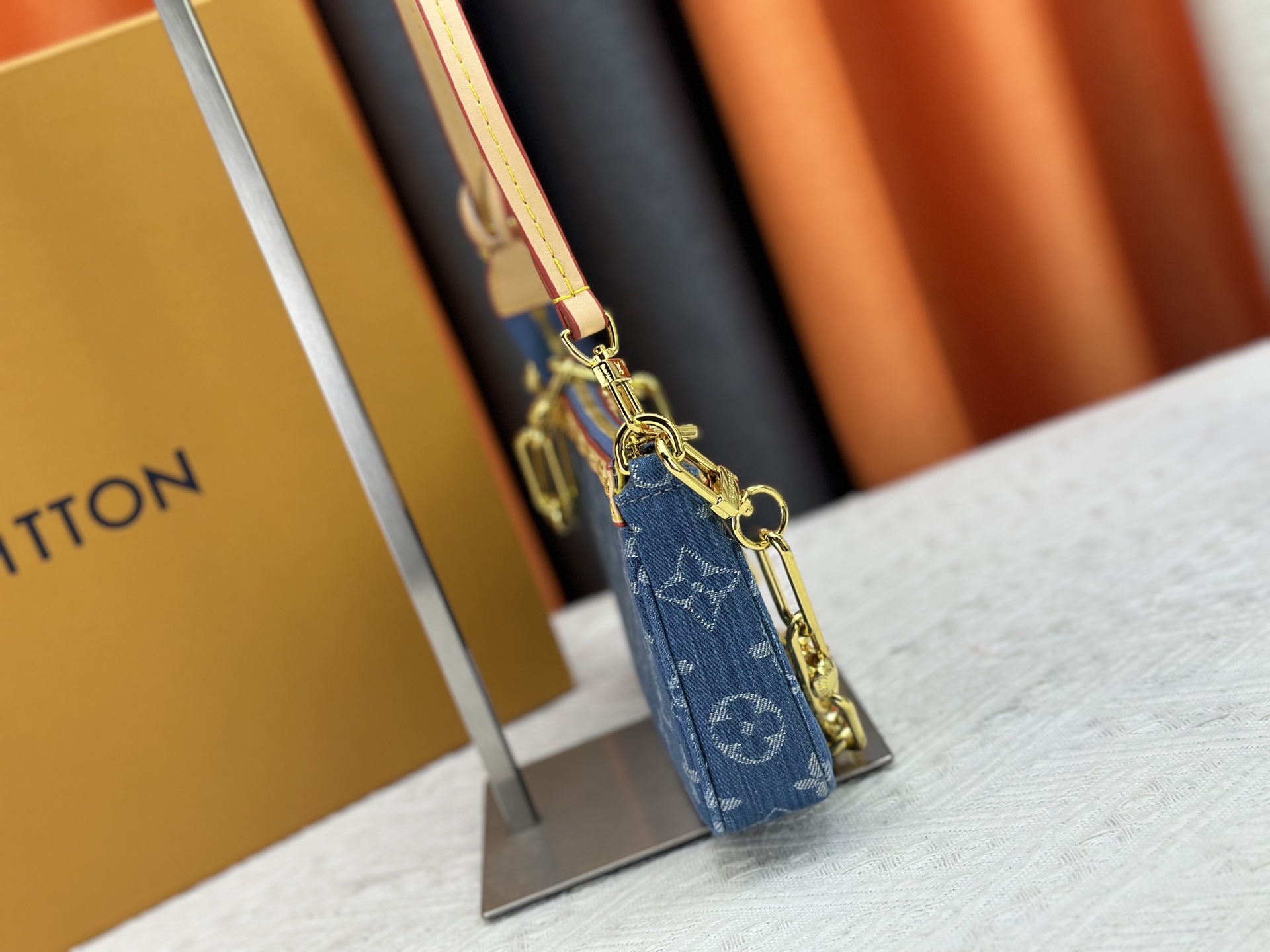 P165 M13404 丹宁牛仔本款 Pochette Accessoires 手袋取材涂层帆布，以缤纷 Monogram
图案演绎路易威登×村上隆跨界合作系列的灵动格调。牛皮革饰边和
耀目金属件点睛考究细节，可拆卸肩带和链条实现灵活背携。尺寸：22x13x4cm 