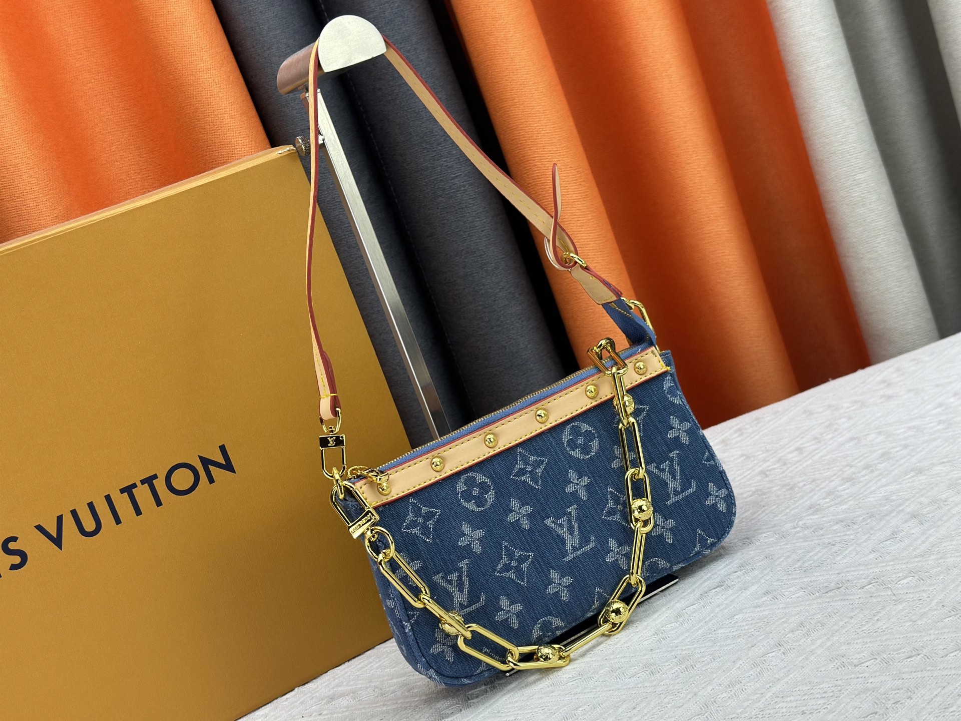 P165 M13404 丹宁牛仔本款 Pochette Accessoires 手袋取材涂层帆布，以缤纷 Monogram
图案演绎路易威登×村上隆跨界合作系列的灵动格调。牛皮革饰边和
耀目金属件点睛考究细节，可拆卸肩带和链条实现灵活背携。尺寸：22x13x4cm 