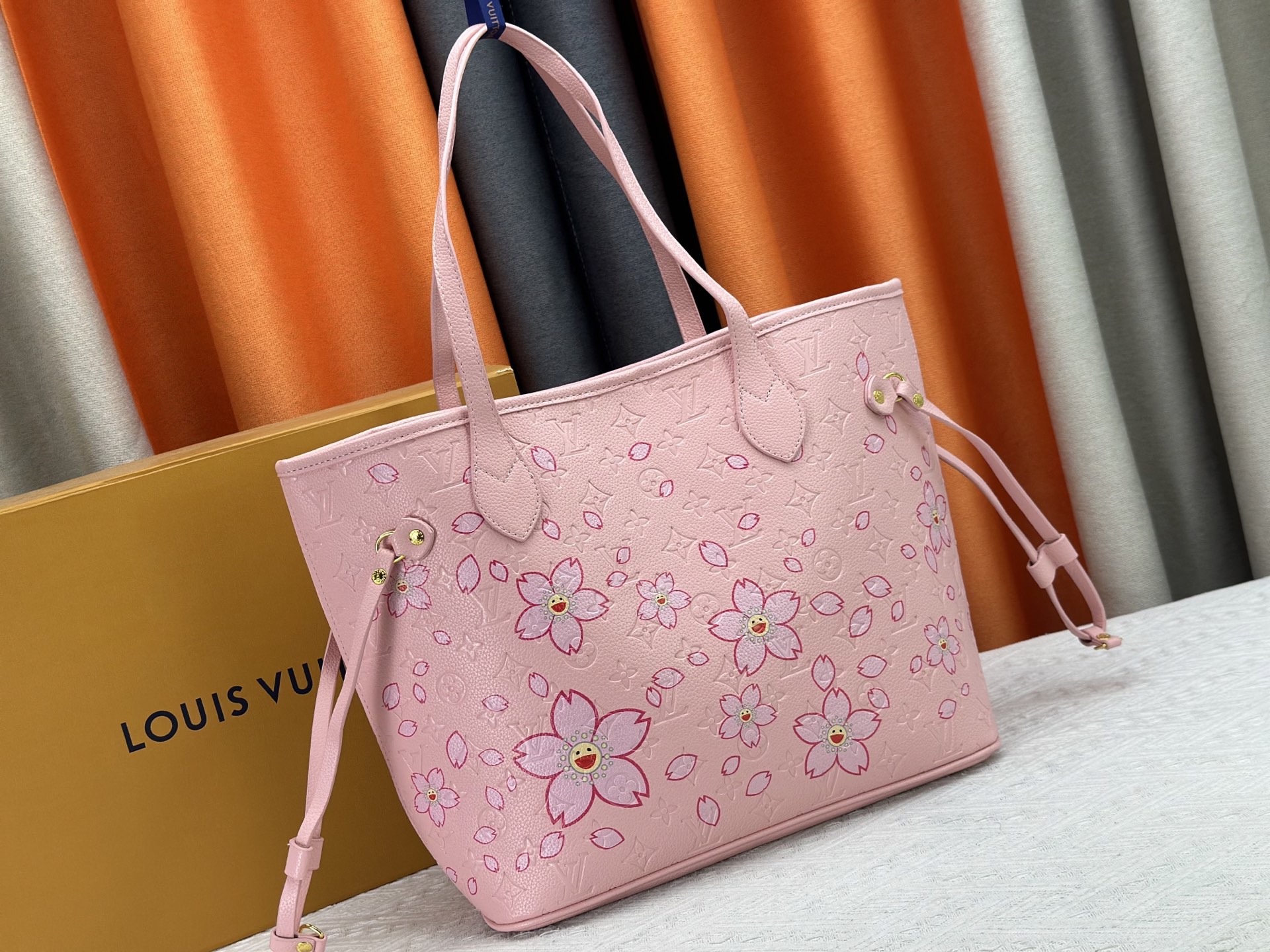 P170 M40995 M17088村上隆 粉色樱花🌸极具传奇色彩的Neverfull中号手袋： 总是能够满足您对手提包的各种需要。 容量大却不显笨重，挺括而手感柔软，居家出行皆宜。 束紧侧边系带，立刻变身为一款时尚的都市手袋。 松开系带，又变成一款别致而实用的手提包。 细长的皮革手柄既宜肩背，亦可挽拎于臂间。 此处显示的此款以 Damier Azur 帆布制成。
尺寸： 31x28x14cm