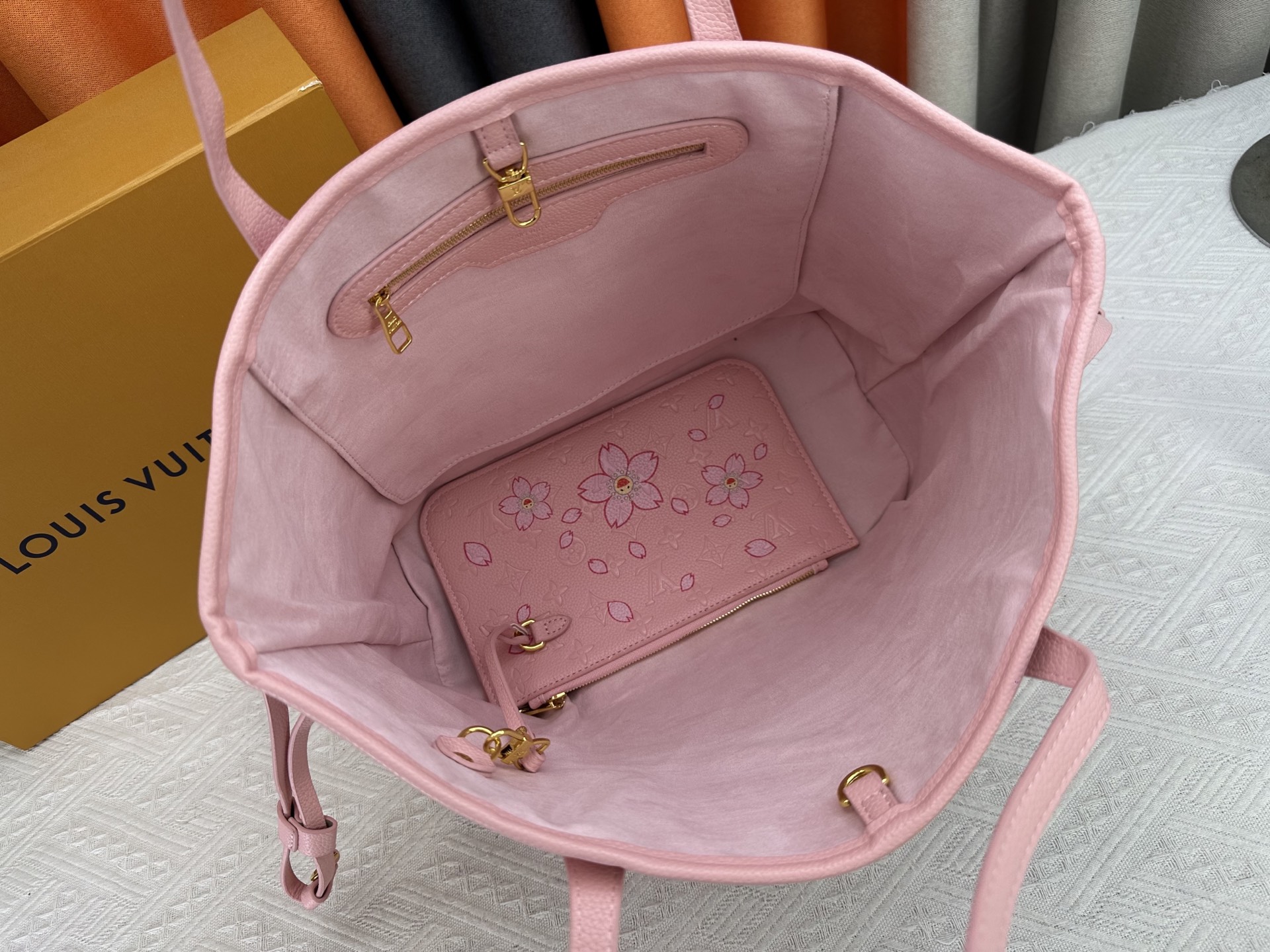 P170 M40995 M17088村上隆 粉色樱花🌸极具传奇色彩的Neverfull中号手袋： 总是能够满足您对手提包的各种需要。 容量大却不显笨重，挺括而手感柔软，居家出行皆宜。 束紧侧边系带，立刻变身为一款时尚的都市手袋。 松开系带，又变成一款别致而实用的手提包。 细长的皮革手柄既宜肩背，亦可挽拎于臂间。 此处显示的此款以 Damier Azur 帆布制成。
尺寸： 31x28x14cm