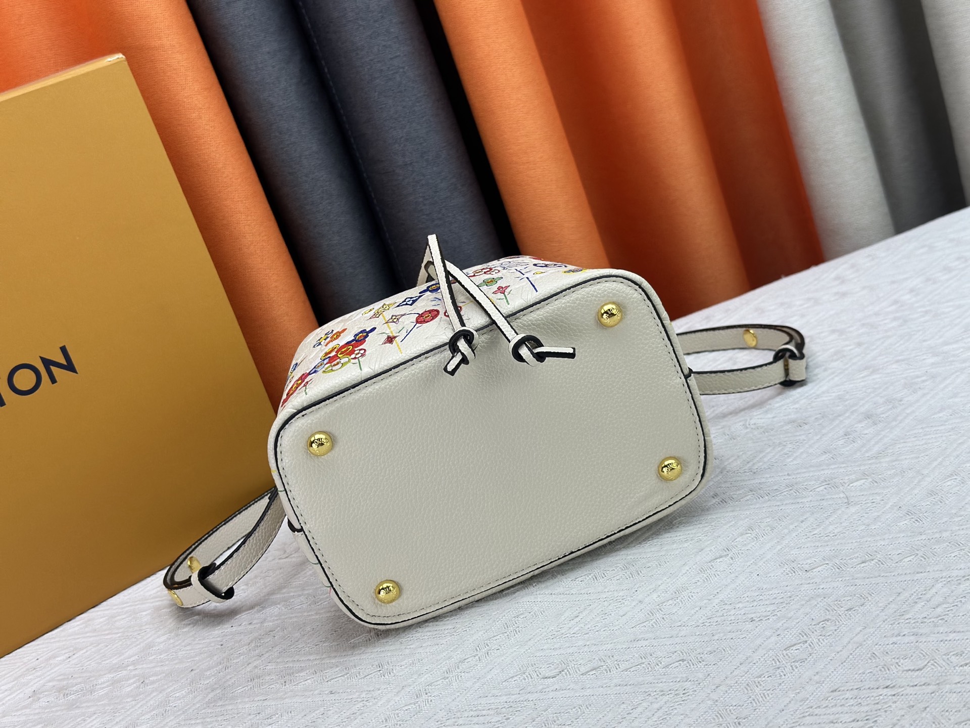 P170 M13676 M44021 本款 NeoNoe BB 水桶包出自路易威登 &times;村上隆复刻系列，以Monogram Empreinte 皮革传递清新气息与灵动格调。Monogram 压纹表面浮现村上隆笔下标志性的 Cherry Blossom 图案，相同花卉元素化作滑扣束紧抽绳。尺寸：20x20x13cm 