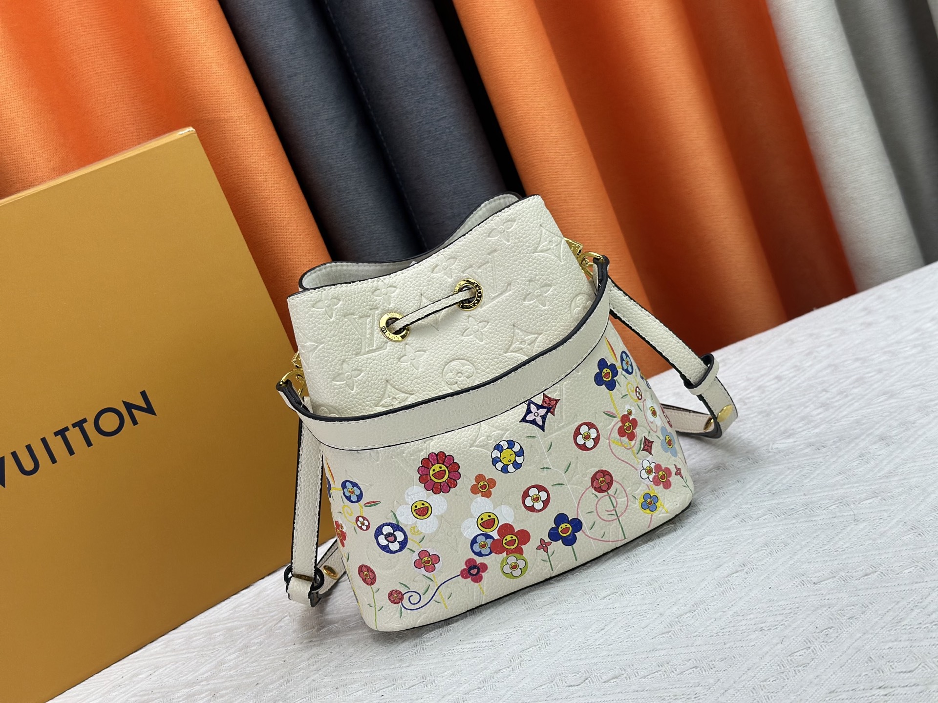 P170 M13676 M44021 本款 NeoNoe BB 水桶包出自路易威登 &times;村上隆复刻系列，以Monogram Empreinte 皮革传递清新气息与灵动格调。Monogram 压纹表面浮现村上隆笔下标志性的 Cherry Blossom 图案，相同花卉元素化作滑扣束紧抽绳。尺寸：20x20x13cm 