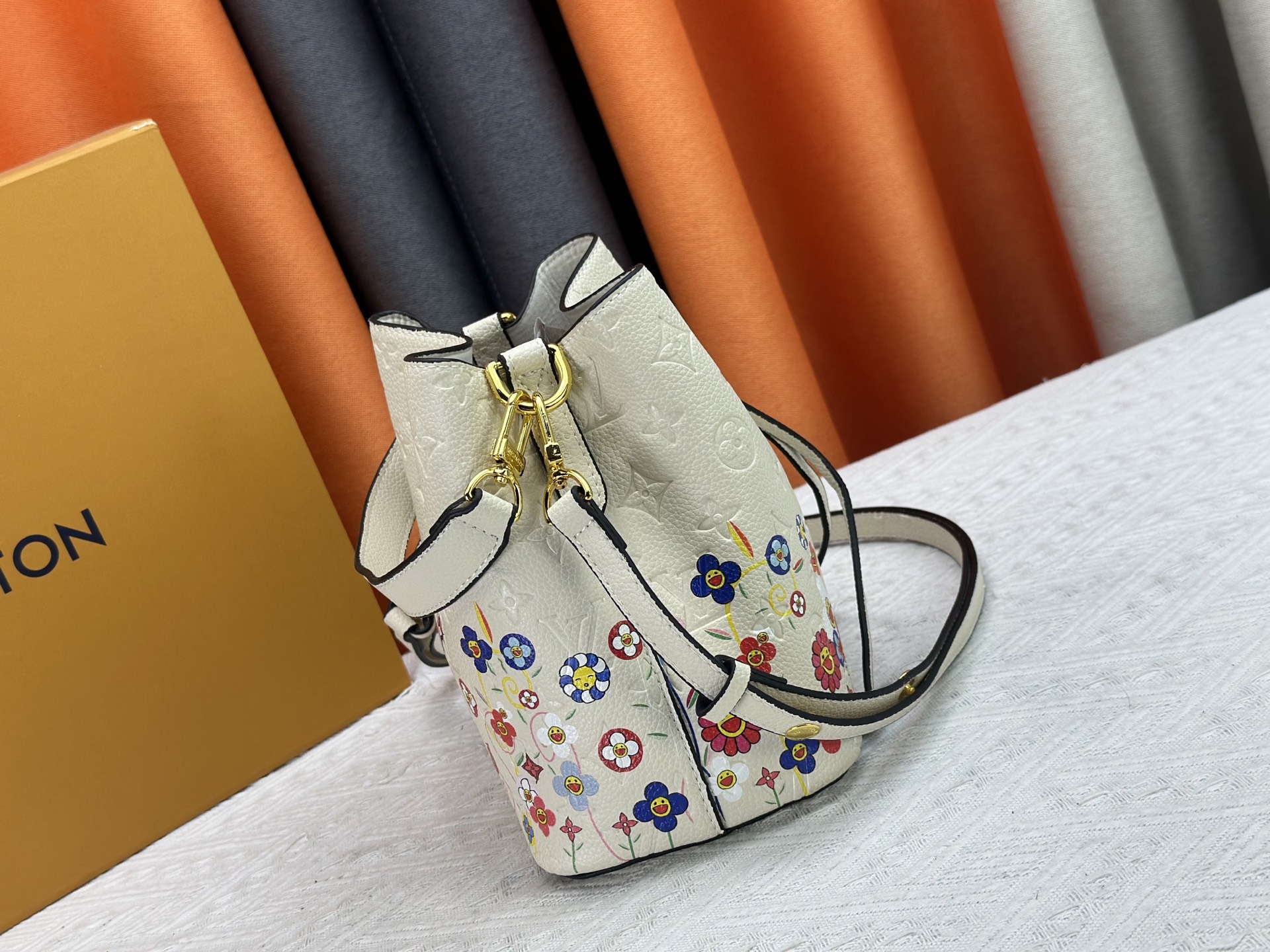 P170 M13676 M44021 本款 NeoNoe BB 水桶包出自路易威登 &times;村上隆复刻系列，以Monogram Empreinte 皮革传递清新气息与灵动格调。Monogram 压纹表面浮现村上隆笔下标志性的 Cherry Blossom 图案，相同花卉元素化作滑扣束紧抽绳。尺寸：20x20x13cm 