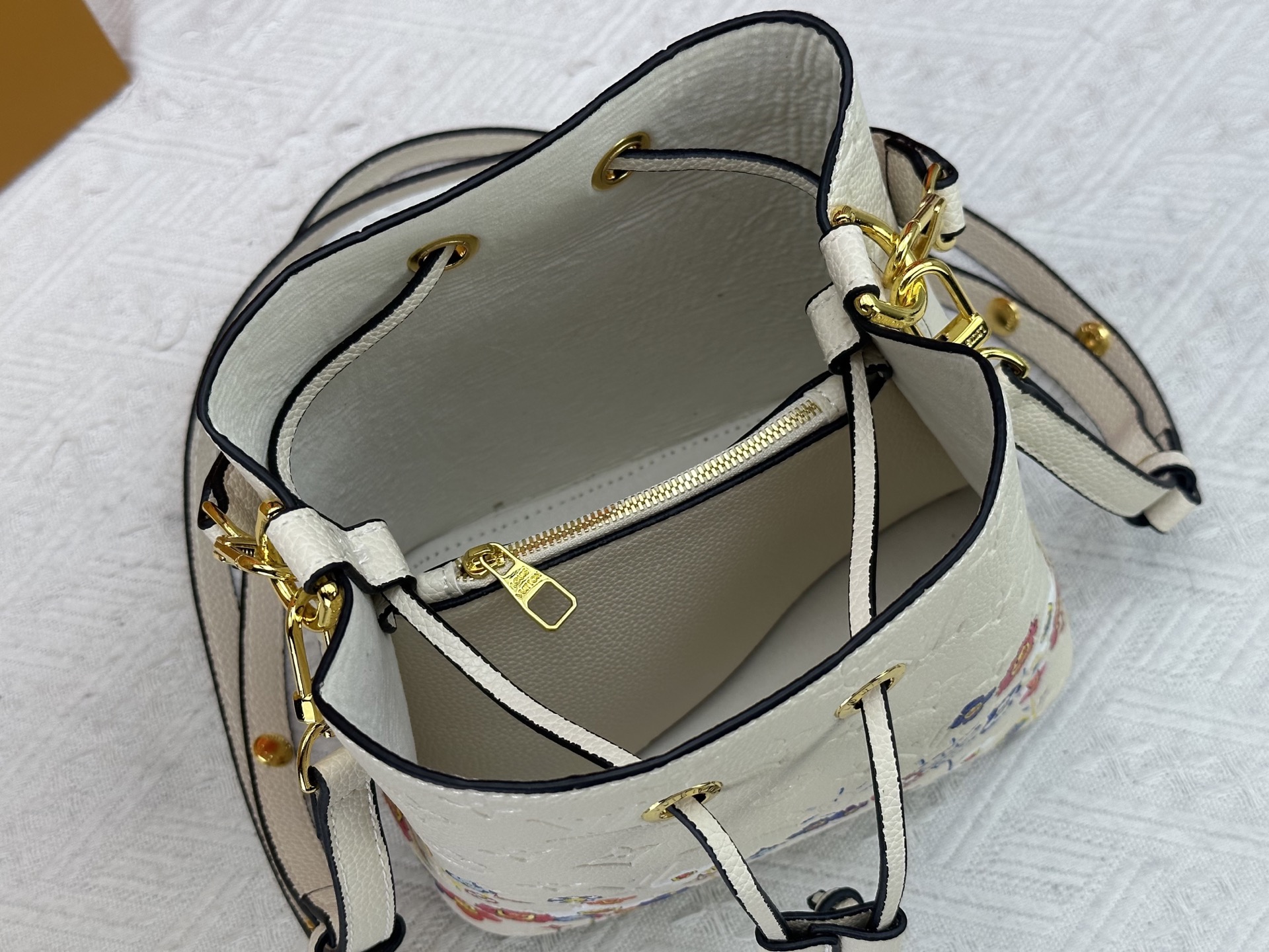 P170 M13676 M44021 本款 NeoNoe BB 水桶包出自路易威登 &times;村上隆复刻系列，以Monogram Empreinte 皮革传递清新气息与灵动格调。Monogram 压纹表面浮现村上隆笔下标志性的 Cherry Blossom 图案，相同花卉元素化作滑扣束紧抽绳。尺寸：20x20x13cm 