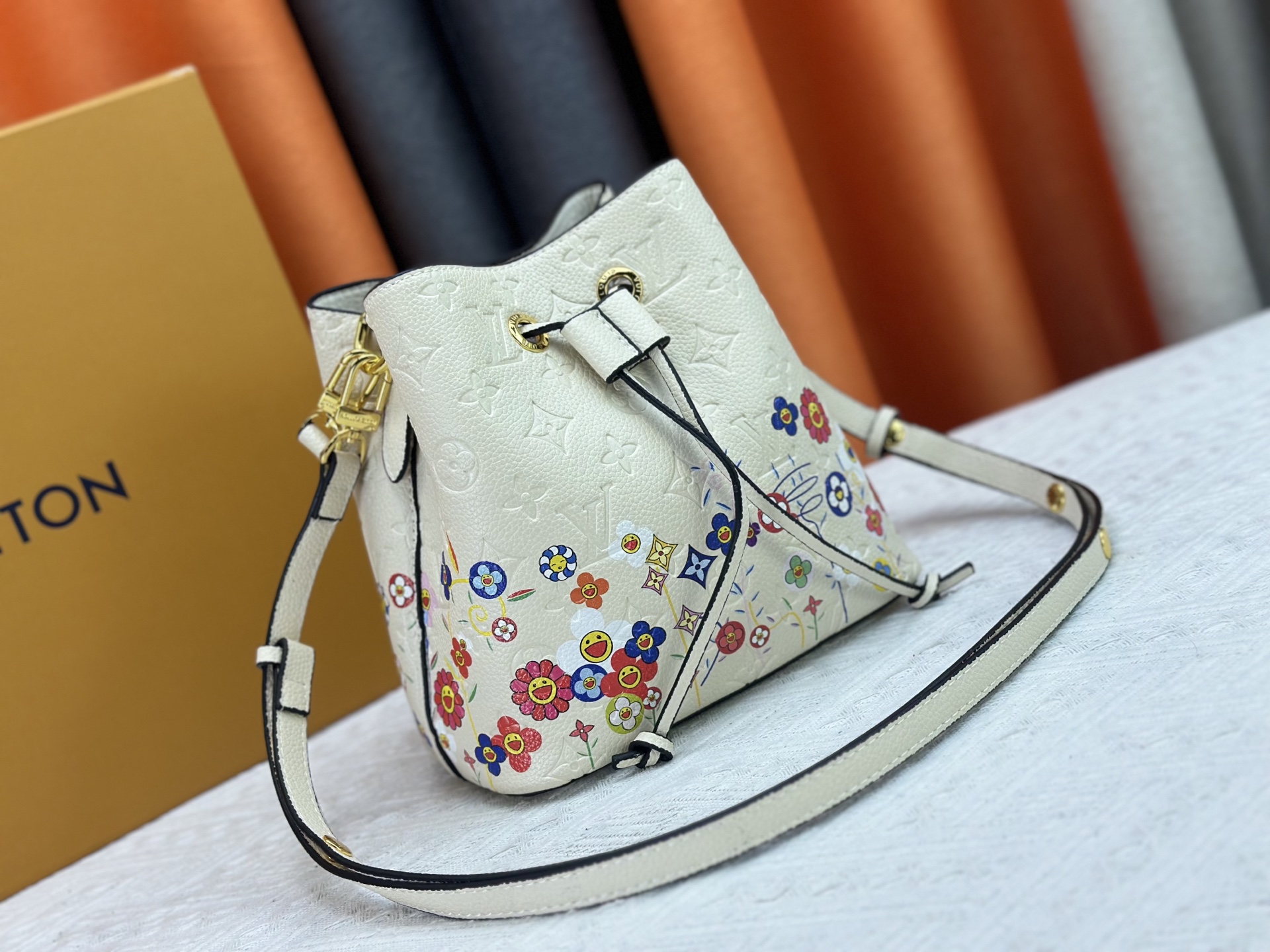 P170 M13676 M44021 本款 NeoNoe BB 水桶包出自路易威登 &times;村上隆复刻系列，以Monogram Empreinte 皮革传递清新气息与灵动格调。Monogram 压纹表面浮现村上隆笔下标志性的 Cherry Blossom 图案，相同花卉元素化作滑扣束紧抽绳。尺寸：20x20x13cm 