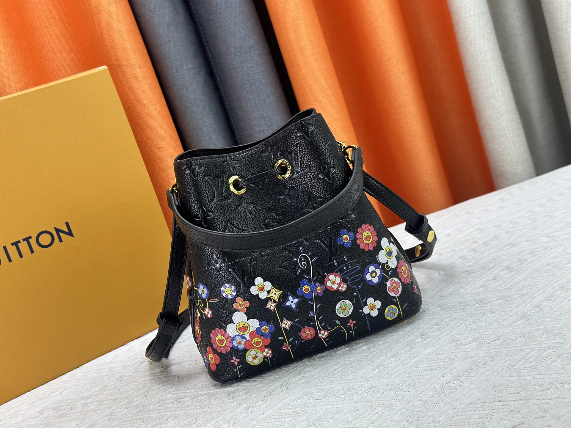 P170 M13676 M44021 本款 NeoNoe BB 水桶包出自路易威登 ×村上隆复刻系列，以Monogram Empreinte 皮革传递清新气息与灵动格调。Monogram 压纹表面浮现村上隆笔下标志性的 Cherry Blossom 图案，相同花卉元素化作滑扣束紧抽绳。尺寸：20x20x13cm 