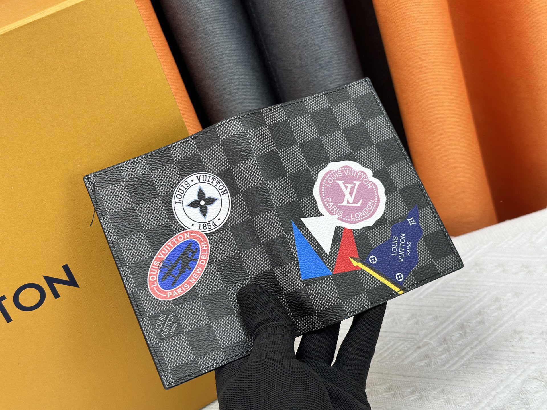 M64502 ブラック徽章パスポートケース - 上質な小牛皮使用の旅行アクセサリー