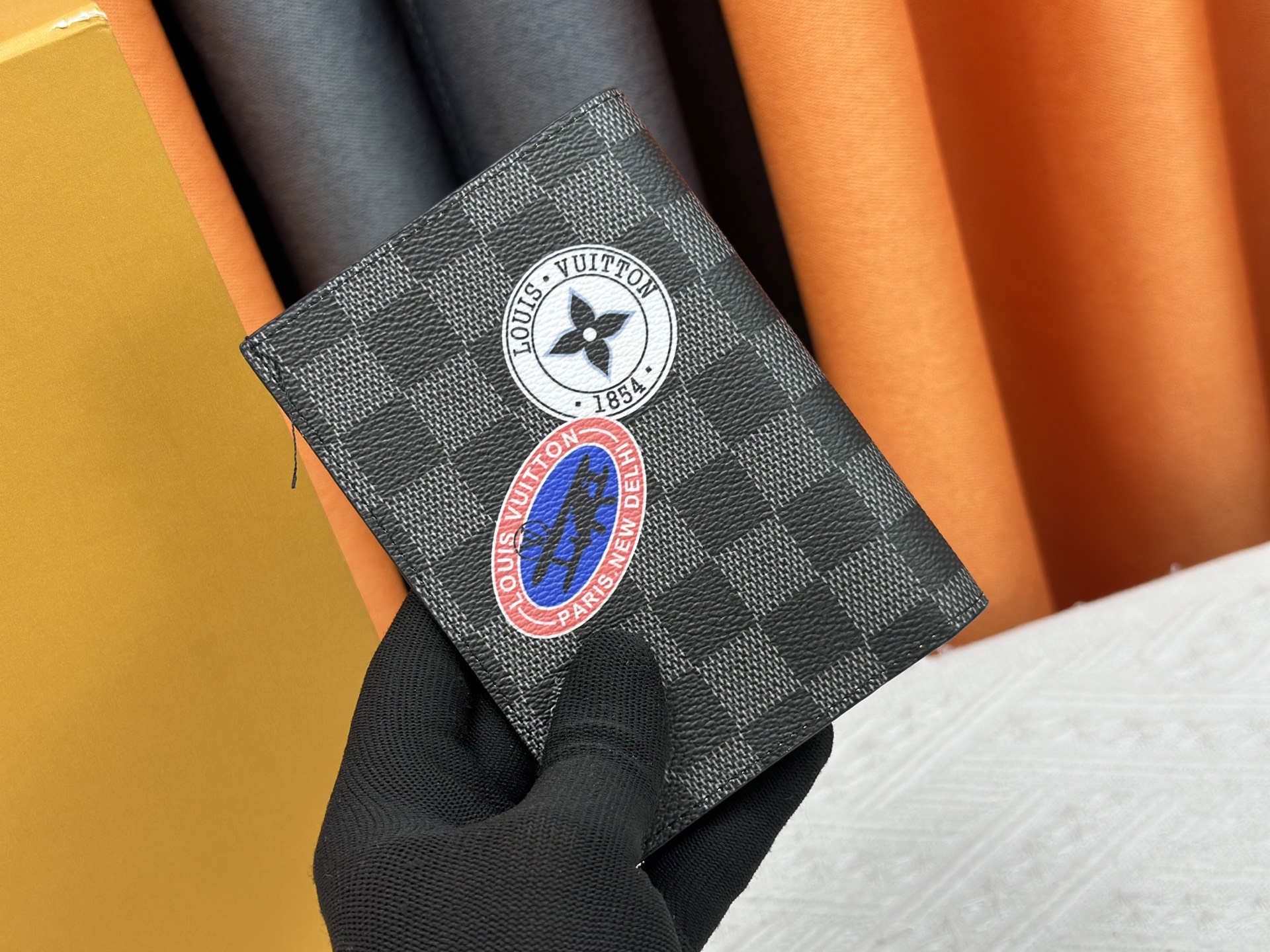 M64502 ブラック徽章パスポートケース - 上質な小牛皮使用の旅行アクセサリー