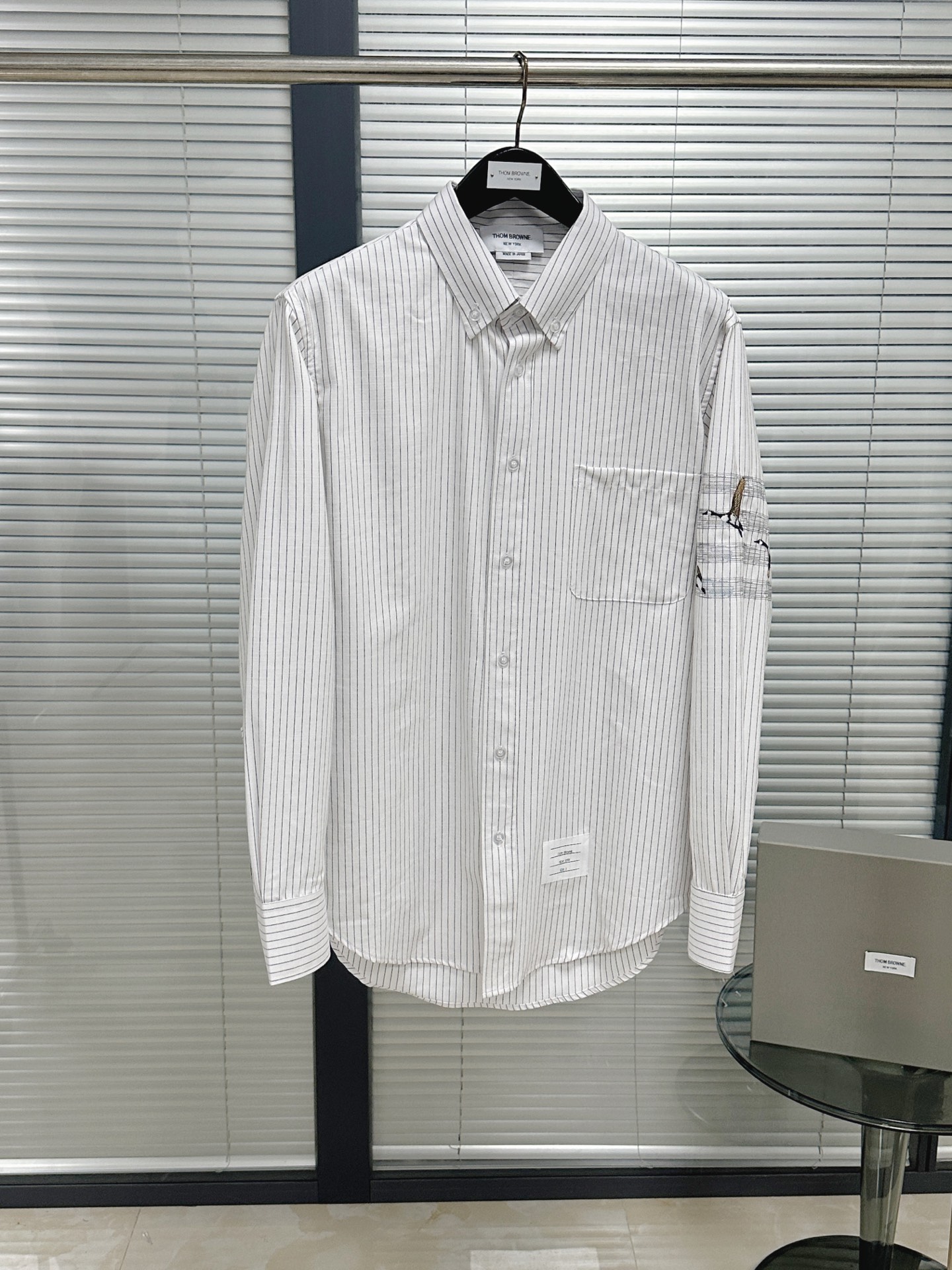 NO:783580,Shirt | TB Wild Goose Embroidered Striped Oxford Cloth Shirt Classic wild goose four-stripe embroidery. The left arm is surrounded by three-dimensional wild geese. It depicts the movement of the wild goose in flight. The four stripes have a virtual and solid feel. Customized striped Oxford cloth imported from Taiwan. The minimum order quantity is 1500 meters; the version has a very wide feel. It looks both casual and formal when worn.  The wild goose pattern symbolizes freedom and ambition. It breaks the monotony of solid-color shirts without being overly ostentatious. It is suitable for men who pursue niche tastes. Paired with suit pants, it is a confident business card for professional elites. Put on jeans and instantly become a casual and trendy man. One shirt can handle meetings, dates, and travel in various occasions. It is a layering tool in autumn. Pair it with a turtleneck sweater or outer jacket. The embroidery element becomes the finishing touch of the overall look. Size1.2.3.4, Thom Brown-Clothing, Thom  browne,jeans,jackets & coats,shirts,business suit,19860909衬衫｜TB大雁刺绣条纹牛津布衬衫 大雁四条纹经典刺绣 左臂大雁立体环绕 描绘了大雁在飞行状态下的运动轨迹 四条纹虚虚实实感 台湾进口定制的条纹牛津布 起订量1500米；版型具有挺阔感 look穿搭起来既休闲又显得正式跟隆重 大雁图案象征自由与远志,既打破纯色衬衫的单调,又不过分张扬,适合追求小众品味的男士. 搭配西装裤是职场精英的自信名片,换上牛仔裤秒变休闲潮男,一件衬衫驾驭会议、约会、旅行多种场合,秋季叠穿神器,内搭高领针织衫或外罩夹克,刺绣元素成为整体造型的点睛之笔 Size1.2.3.4,汤姆布朗-服装,thom browne,jeans,jackets & coats,shirts,business suit,,Women's clothing