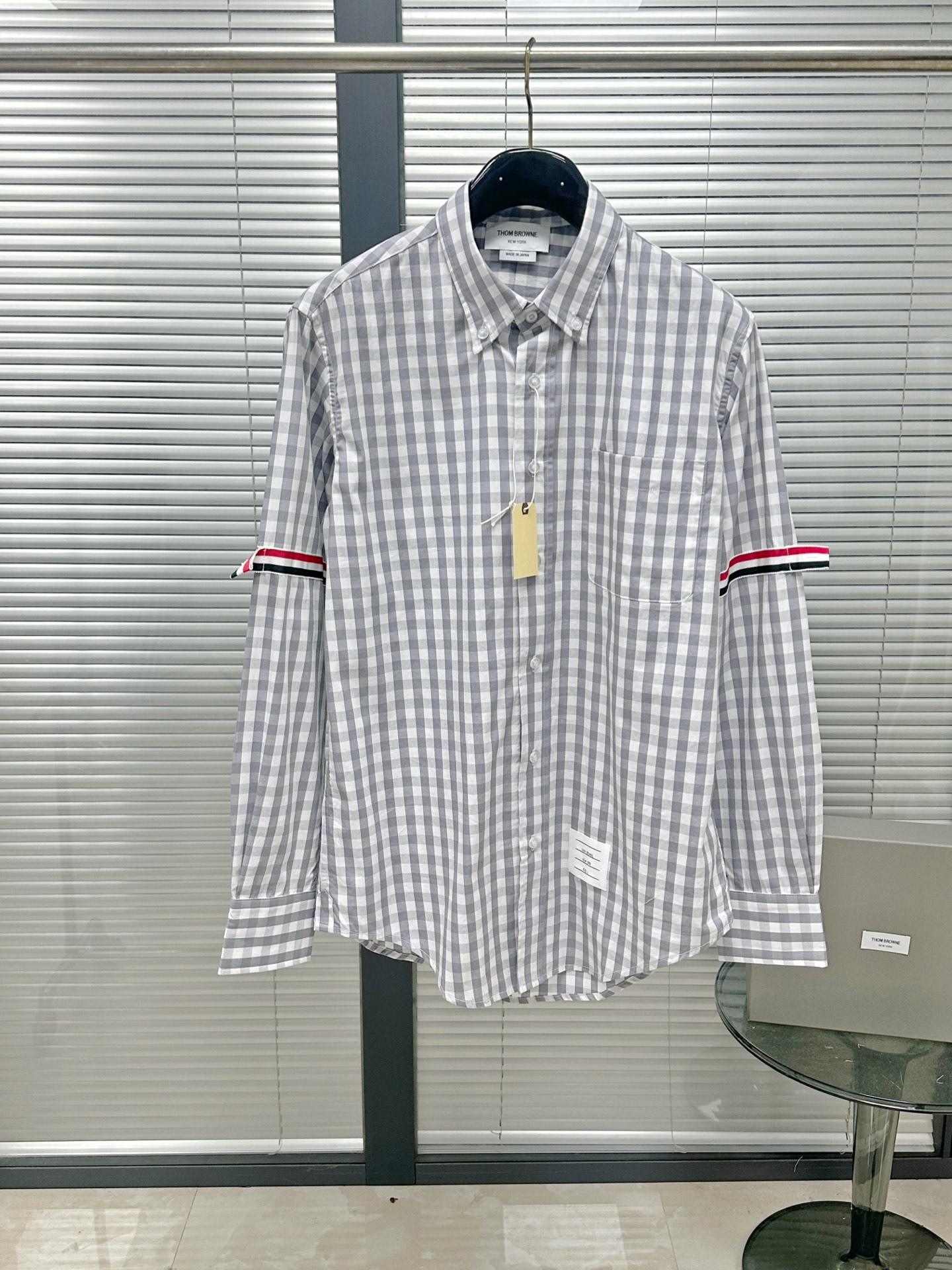 NO:783359,Shirt | TB double armband plaid long-sleeved shirt. The gray and white plaid poplin shirt has the right sense of American college relaxation. The pure cotton poplin has just the right crispness, and the upper body is breathable and non-sticky. The gray-toned small plaid has a clean bookish air, and the sleeve and arm webbing quietly adds a bit of fun recognition.  The tailoring is the brand's signature slightly wide dropped shoulders, which is not too rigid. It is effortless and casual when worn with jeans, and it can reveal a restrained sense of refinement when paired with trousers. Every detail says 'not hard, but very particular' Size1.2.3.4, Thom Browne-clothing,thom browne,jeans,shirts,19860909衬衫｜TB双袖标格纹长袖衬衣 灰白格府绸衬衫,把美式学院的松弛感做得恰到好处. 纯棉府绸的挺括感刚刚好,上身是透气不贴肤的自在,灰调小格纹自带干净的书卷气,袖臂织带又悄悄添了几分玩趣的辨识度. 剪裁是品牌标志性的微阔落肩,不会过分板正,搭牛仔裤是毫不费力的随性,配西裤又能透出克制的精致感,每一处细节都在说“不用力,却很讲究” Size1.2.3.4,汤姆布朗-服装,thom browne,jeans,shirts,,Women's clothing