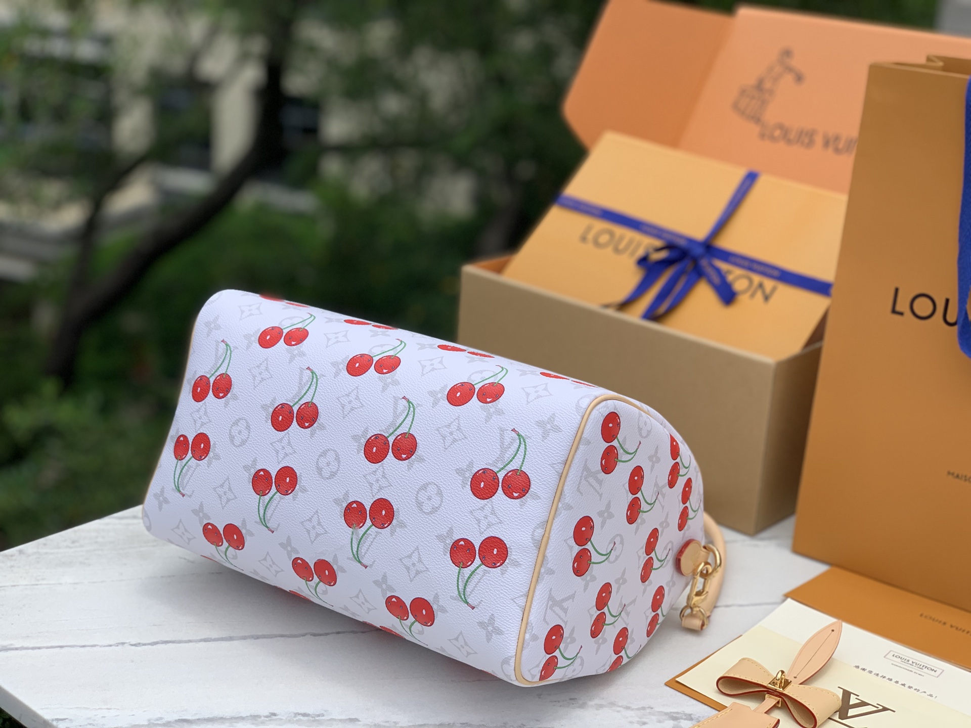 【原厂特惠】💰1180 m14238  尺寸:30×21×17cm 
LV村上系列的樱桃枕头包，为经典的Speedy 30，带来了全新的时尚视角，甜美的樱桃图案以其鲜明且欢乐的色彩，巧妙地融合于品牌标志性的Monogram涂层帆布之上，形成了独特而引人注目的视觉效果，既展现了品牌的经典底蕴，又不失现代时尚的活力。同时，天然皮革材质精心打造的Toron顶部手柄、可拆卸表带以及独家LV x TM锁头，不仅在质感上体现了极致的奢华，更在细节处彰显了品牌对品质的执着追求。无论是商务场合还是重要社交活动，这款樱桃枕头包都能成为您彰显品味与风格的不二之选。