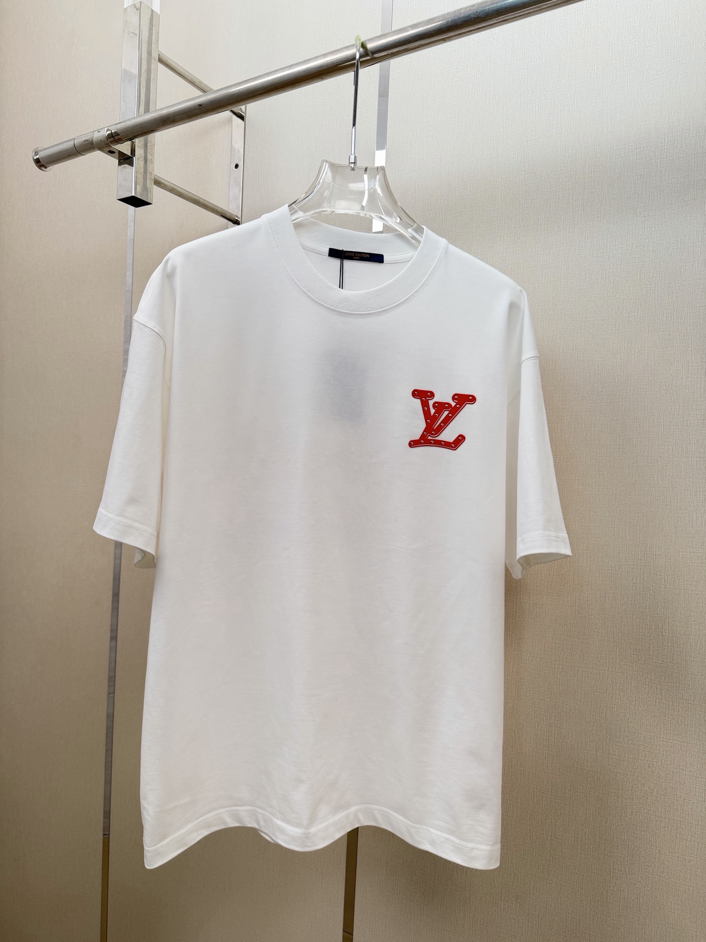 P90 Camiseta LV espalda logo grande estilo retro americano, letras rojas en contraste con ambiente callejero, adornada …