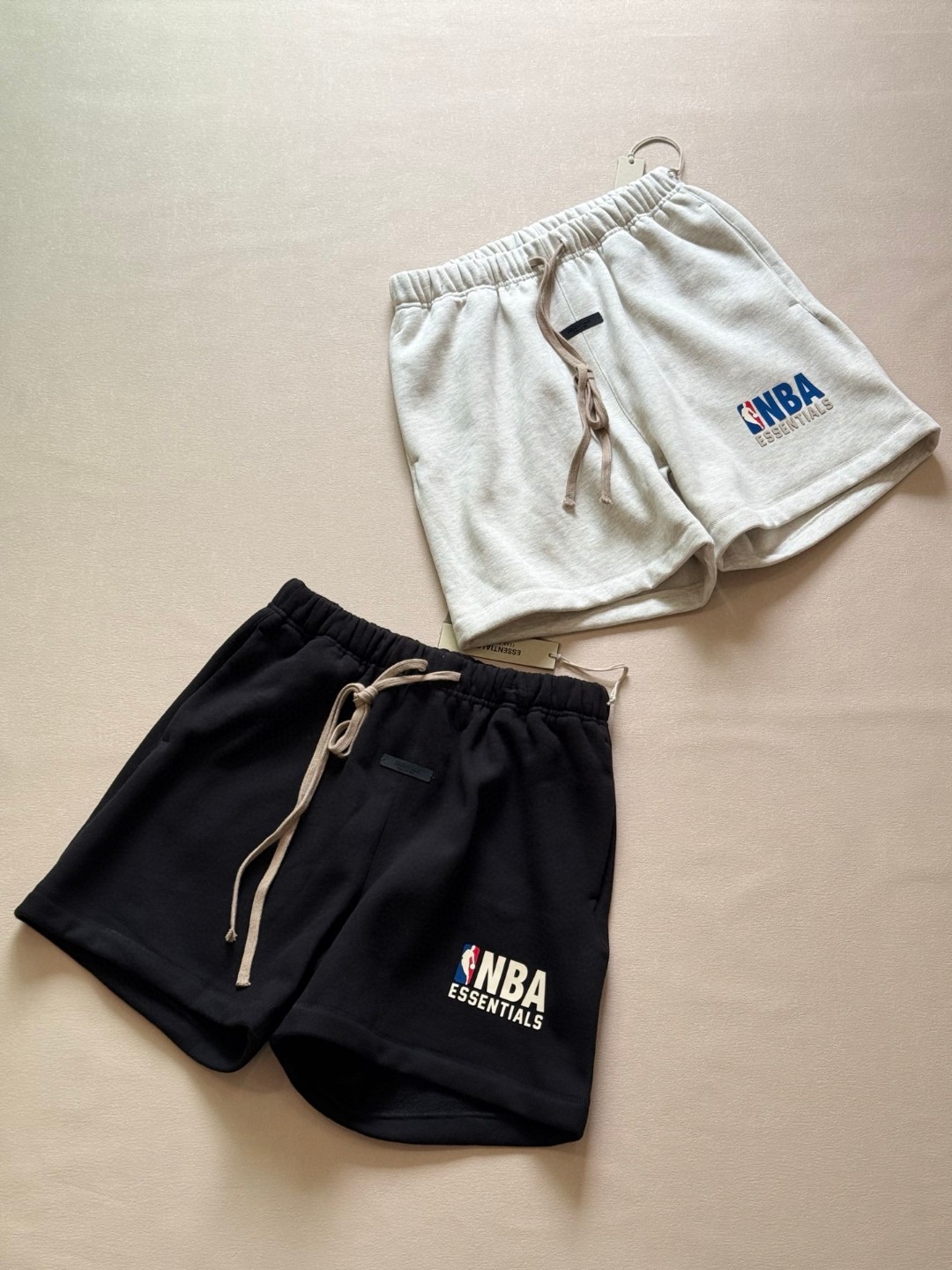 P145


💰ESSENTIALS联名NBA全明星春夏宽松短裤：美式高街潮牌的代表之作。它是街头潮牌fear of god的副线品牌，由美国著名设计师jerry lorenz于2018年创立，简约、奢华、实用完美融合，从诞生起就备受潮流人士追捧。
今年它更是与全明星NBA联名，直接将街头潮流与热血篮球激情碰撞。穿上它，仿佛能感受到赛场上的热烈氛围，运动活力与时尚感双双拉满。而且，它宽松的版型，对各种身材的朋友都超友好，无论是运动时的舒展，还是日常出街的随性，都能轻松拿捏。
原厂订制原面料选用100%及以上含量的精梳棉，透气又耐磨，色牢度高，久穿不变形、不褪色，克重400g，质感满满。圆领设计简洁大方，落肩袖更添慵懒随性，不管是搭配运动裤，还是休闲牛仔裤，都能轻松打造出属于你的潮流风格。不管你是篮球迷，还是潮流达人，这款短袖都不容错过，还不赶紧入手，让自己成为这个夏天最靓的仔！。       
 陨石黑、浅雾灰：S M L XL
s80-140斤
m140-160斤
L160-180斤
XL180-200斤