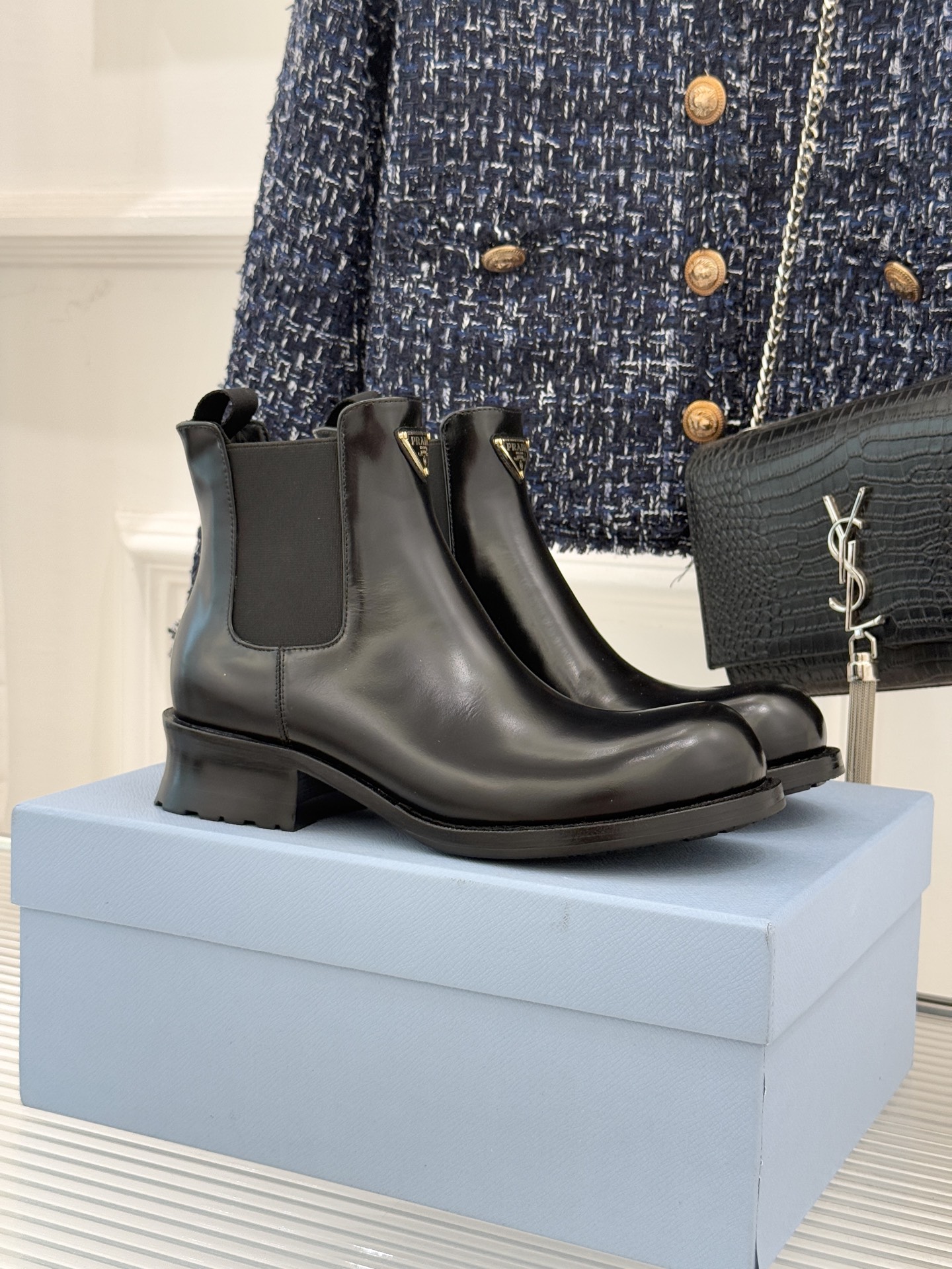 NO:564021,Prada/Prada classic corner logo Chelsea thick-heeled short boots. When the classic genes of Chelsea boots meet the iconic aesthetics, these short boots have become the style anchor of autumn and winter wear. The brand's design philosophy is hidden in the steps. The soul of the shoe body is undoubtedly the enameled metal triangle logo. The warm luster and metallic texture collide to highlight the brand recognition with minimalist symbols. The boot body is made of iconic bright open-edge beaded leather. The 16 cm boot height fits the ankle just right.  It looks neat and can modify the shape of the legs. The elastic pull tab on the side is a classic element of Chelsea boots. It is easy to put on and take off and fits well. It is a style tool that transcends scenes. Paired with an oversized suit and a short skirt, it has a smart aura in the urban workplace. Pair it with a denim jacket and straight pants to create a casual and uninhibited street style, while balancing the retro charm of softness and strength.   From daily commuting to weekend walks, the leather lining brings a delicate sense of wrapping. The thick heel design makes every step steady and light. The fabric is made of customized open-edge beaded cowhide. The lining and tiptoe are all cowhide. Italian imported genuine leather combination outsole size35-39 (customized 40/41), boots, prada, prada, versace, boots, skirts, jackets & coats, business suit, cowhide19860909Prada/普拉达经典角标切尔西粗跟短靴 当切尔西靴的经典基因遇上标志性美学 这双短靴便成了秋冬穿搭的风格锚点 将品牌的设计哲学藏于步履之间. 而鞋身的灵魂无疑是涂珐琅金属三角标 温润光泽与金属质感碰撞 以极简符号彰显品牌辨识度 靴身以标志性的亮面开边珠皮革裁制 16厘米的靴筒高度恰好贴合脚踝 既显利落又能修饰腿型 侧面的弹力拉环是切尔西靴的经典元素 兼顾穿脱便捷与贴合度 它是跨越场景的风格利器 搭配oversized西装与短裙 是都市职场的干练气场 配牛仔外套与直筒裤 演绎随性不羁的街头格调 又平衡出柔与刚的复古韵味. 从日常通勤到周末漫步 皮革衬里带来细腻包裹感 粗跟设计让每一步都稳健又轻盈. 面料采用定制开边珠牛皮 内里踮脚均为牛皮 意大利进口真皮组合大底 size35-39（40/41定制）,靴子,prada,prada,versace,boots,skirts,jackets & coats,business suit,cowhide,Women's Shoes