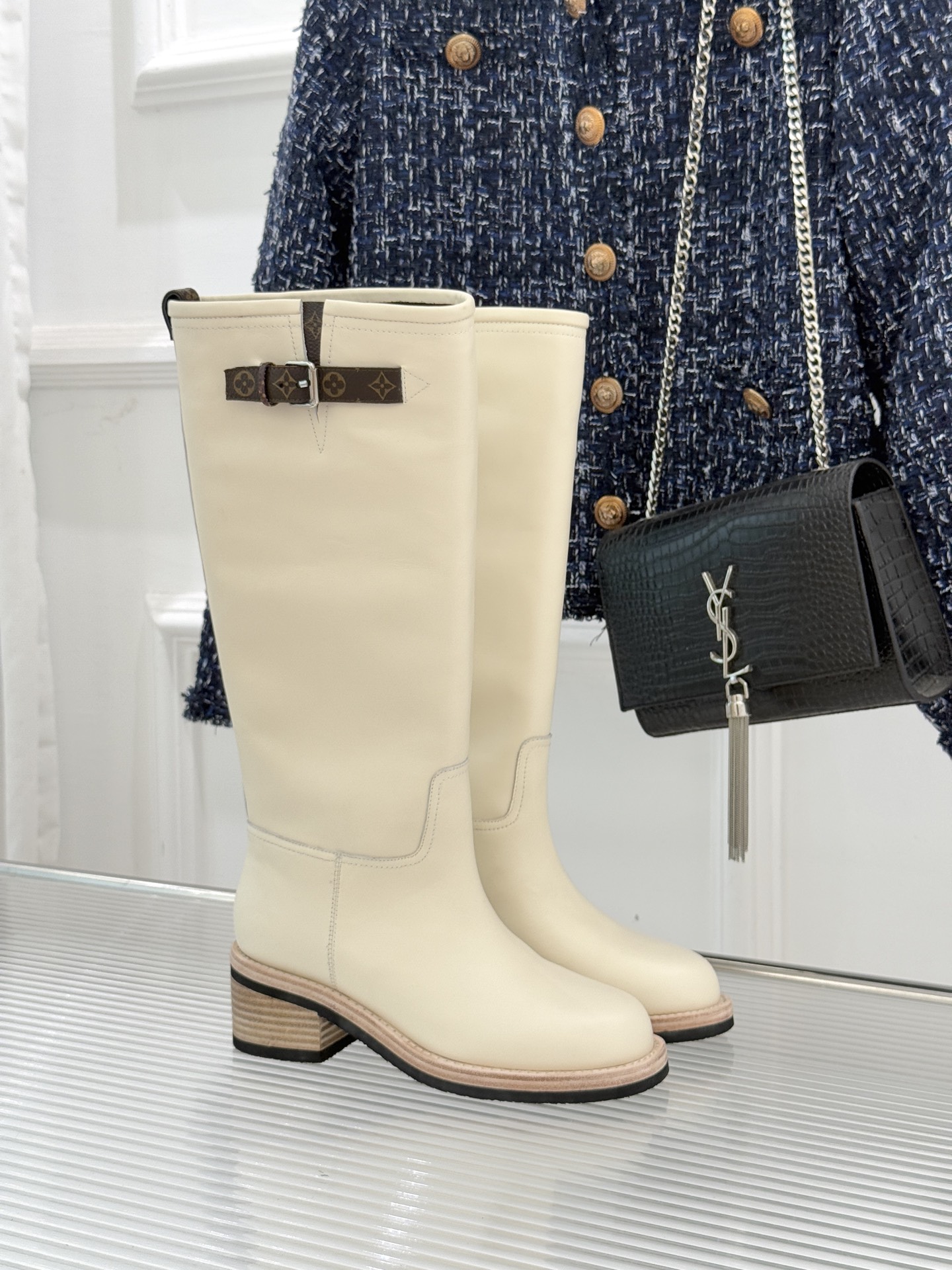 NO:564032,Donkey brand 25WF autumn and winter new presbyopia belt buckle thick heel knight boots. When the sassy style of knight boots meets LV's classic code, these boots become the style totem of autumn and winter. The design concept of the brand is embodied in the aura between steps. The boot body is carefully tailored with fine vegetable tanned calfskin, which is soft to the touch but maintains a stiff boot shape. The adjustable design takes into account both fit and decoration. The interior is lined with soft first-layer cowhide.  It wraps your feet like a second layer of skin. It is equipped with a non-slip and wear-resistant rubber outsole. Every step is both stable and light. The classic pattern of presbyopia and belt buckle echoes back and forth. The exquisite Italian craftsmanship is hidden in the texture. It is a style tool that transcends scenes. Pair it with a suit and shorts for a smart and stylish look for urban commuting. Pair it with a denim jacket and straight trousers to create a casual and uninhibited street style. Pair it with a knitted long skirt.   It is both retro and charming. From daily walks to important occasions, it protects your feet with a 'shelter-like sense of wrapping' and uses an aesthetic that transcends time to make every step a style statement with its own focus. size35-39 (customized 40/41), boots, louis vuitton, louis vuitton, boots, skirts, shorts, jackets & coats, business suit, cowhide19860909驴牌25WF秋冬新品老花皮带扣粗跟 骑士靴长靴 当骑士靴的飒爽风骨邂逅LV的经典密码 这双长靴便成了秋冬的风格图腾 将品牌的设计理念具象为步履间的气场. 靴身以细腻植鞣小牛皮悉心裁制 触感柔软却能保持挺括靴型 调节设计兼顾贴合度与装饰感 内里铺陈柔软头层牛皮 如第二层肌肤般包裹双脚 搭配防滑耐磨的橡胶大底 每一步都兼具安稳与轻盈. 老花与皮带扣的经典纹样前后呼应 将意大利工艺的精湛藏于肌理之中 它是跨越场景的风格利器 搭配西装套装与短裤 是都市通勤的干练洋气 配牛仔外套与直筒裤 演绎随性不羁的街头格调 搭针织长裙 即复古又有韵味. 从日常漫步到重要场合 它以「庇护般的包裹感」守护双脚 更以超越时间的审美 让每一步都成为自带焦点的风格宣言. size35-39（40/41定制）,靴子,louis vuitton,louis vuitton,boots,skirts,shorts,jackets & coats,business suit,cowhide,Women's Shoes