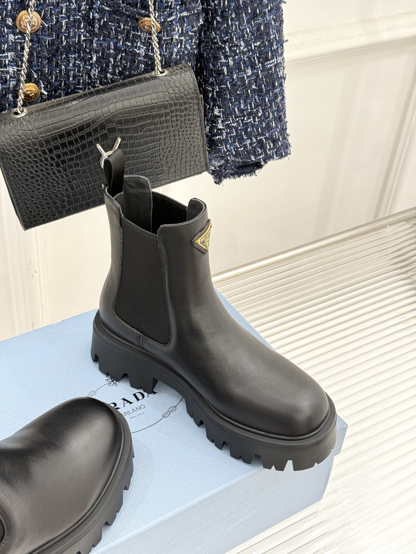 Prada/普拉达经典三角标厚底短靴当米兰的百年匠艺碰撞当代街头美学它不止是秋冬靴履的奢华范本更是跨越潮