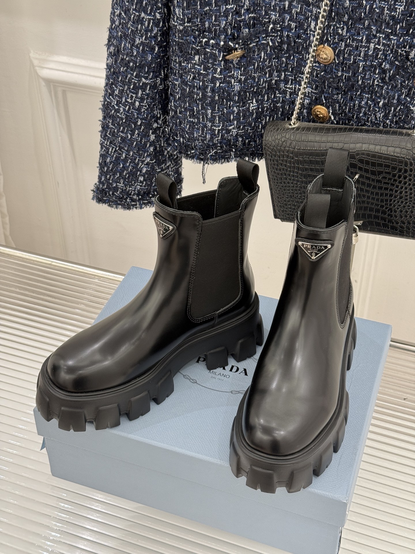 Prada/普拉达经典三角标厚底短靴当米兰的百年匠艺碰撞当代街头美学它不止是秋冬靴履的奢华范本更是跨越潮