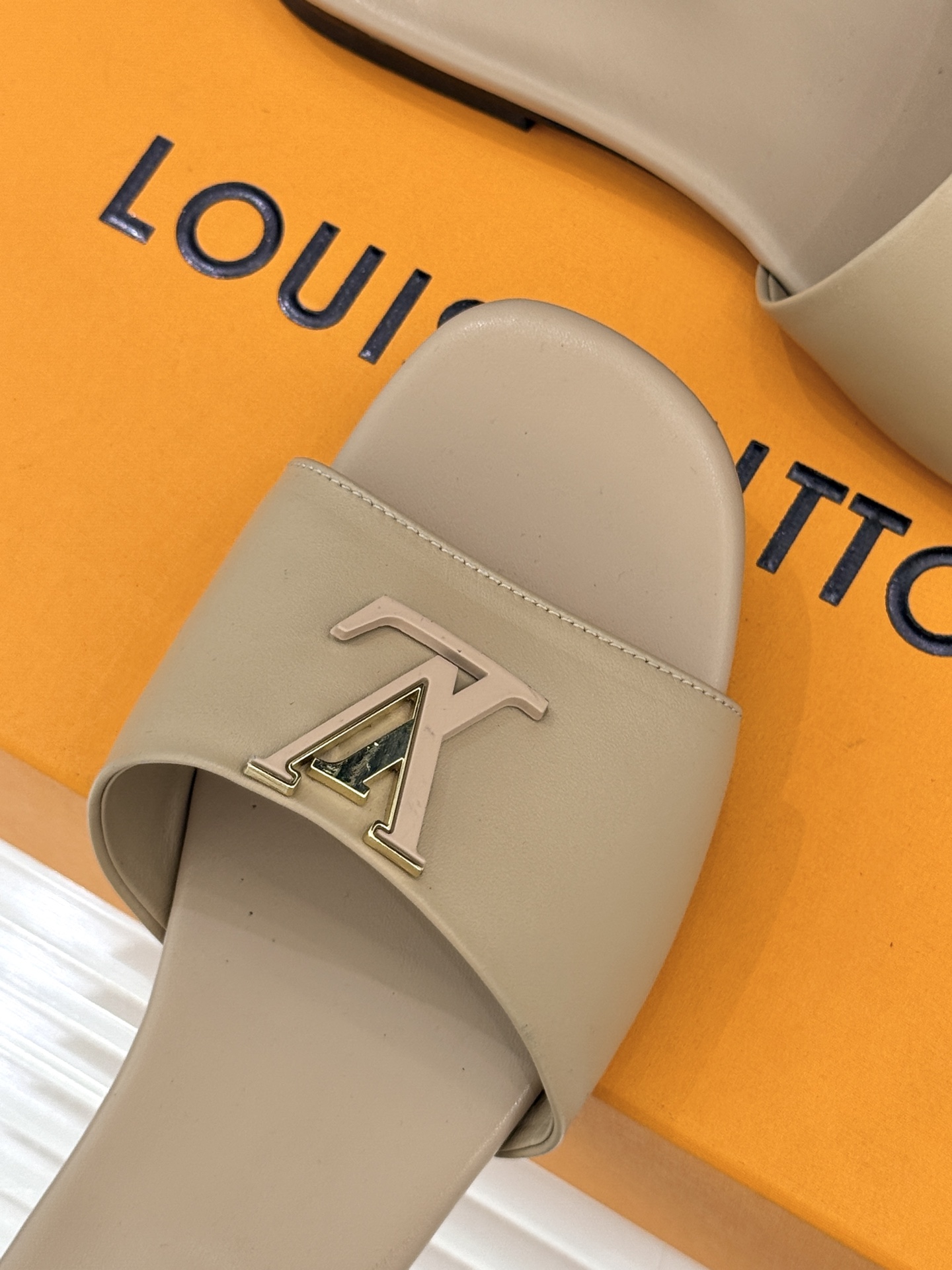 L*V驴牌经典爆款平底拖鞋它的设计简约而不失格调LV标识以金属质感的扣饰形式点缀仿佛将整个品牌的格调与品