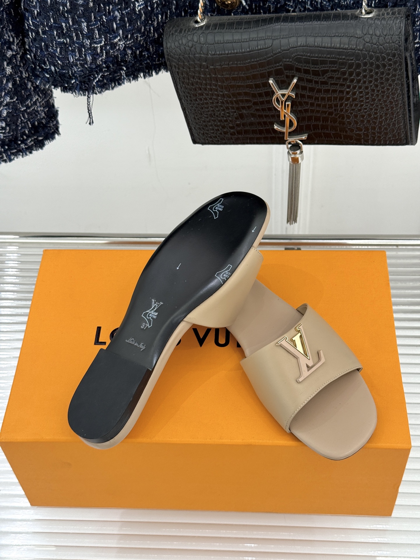 L*V驴牌经典爆款平底拖鞋它的设计简约而不失格调LV标识以金属质感的扣饰形式点缀仿佛将整个品牌的格调与品