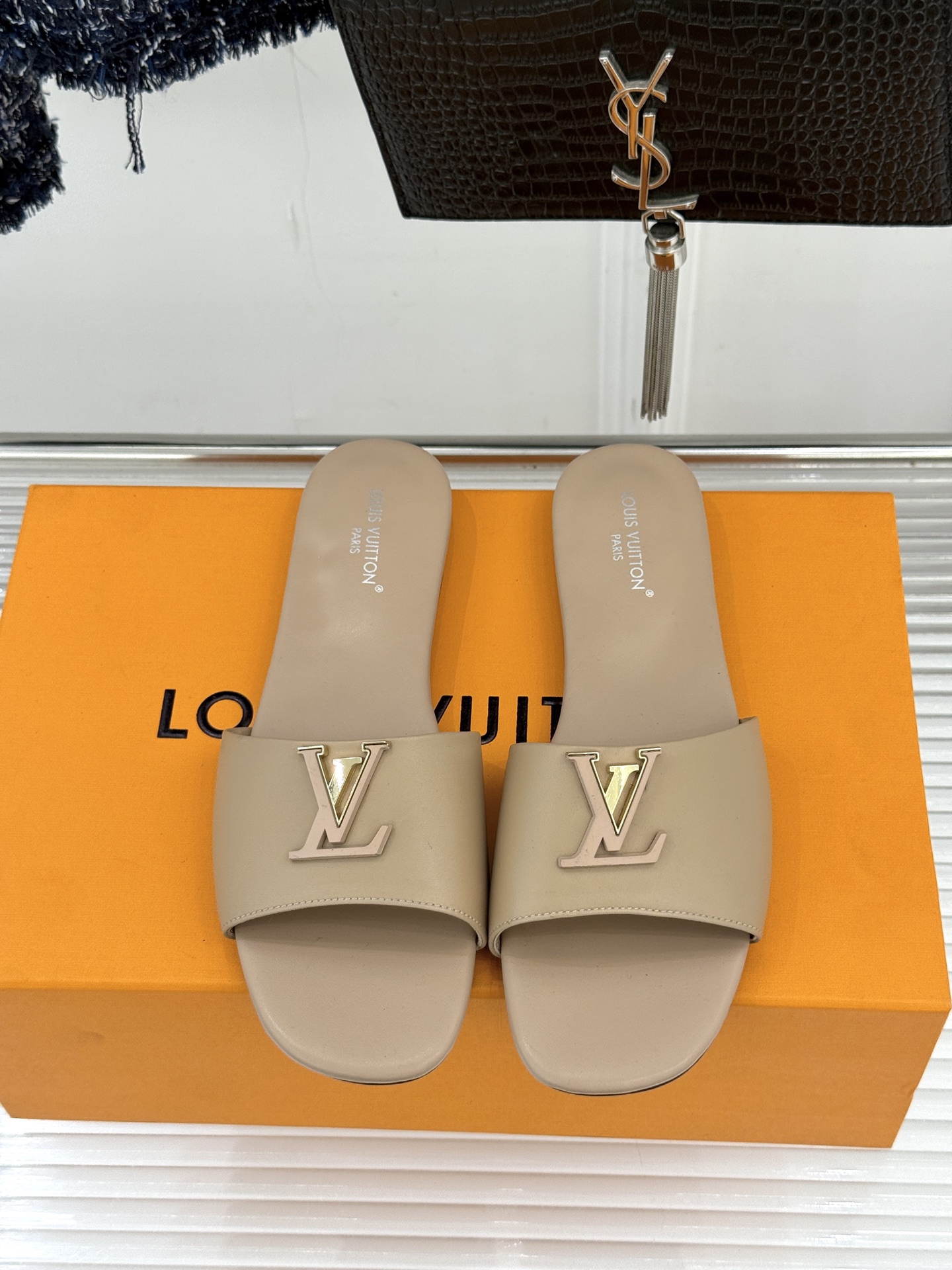 L*V驴牌经典爆款平底拖鞋它的设计简约而不失格调LV标识以金属质感的扣饰形式点缀仿佛将整个品牌的格调与品