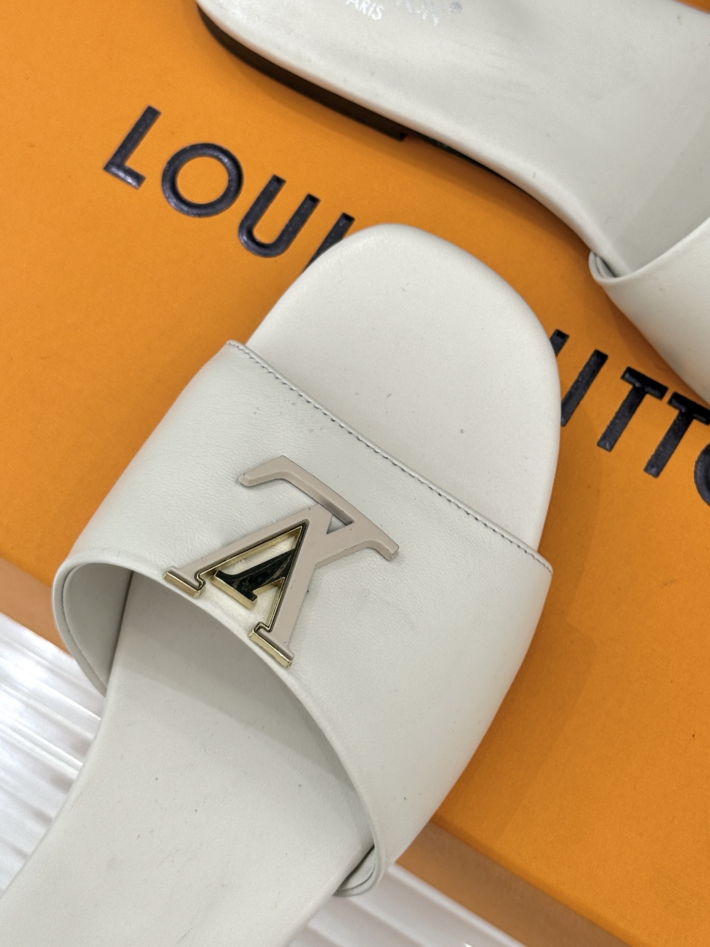 L*V驴牌经典爆款平底拖鞋它的设计简约而不失格调LV标识以金属质感的扣饰形式点缀仿佛将整个品牌的格调与品