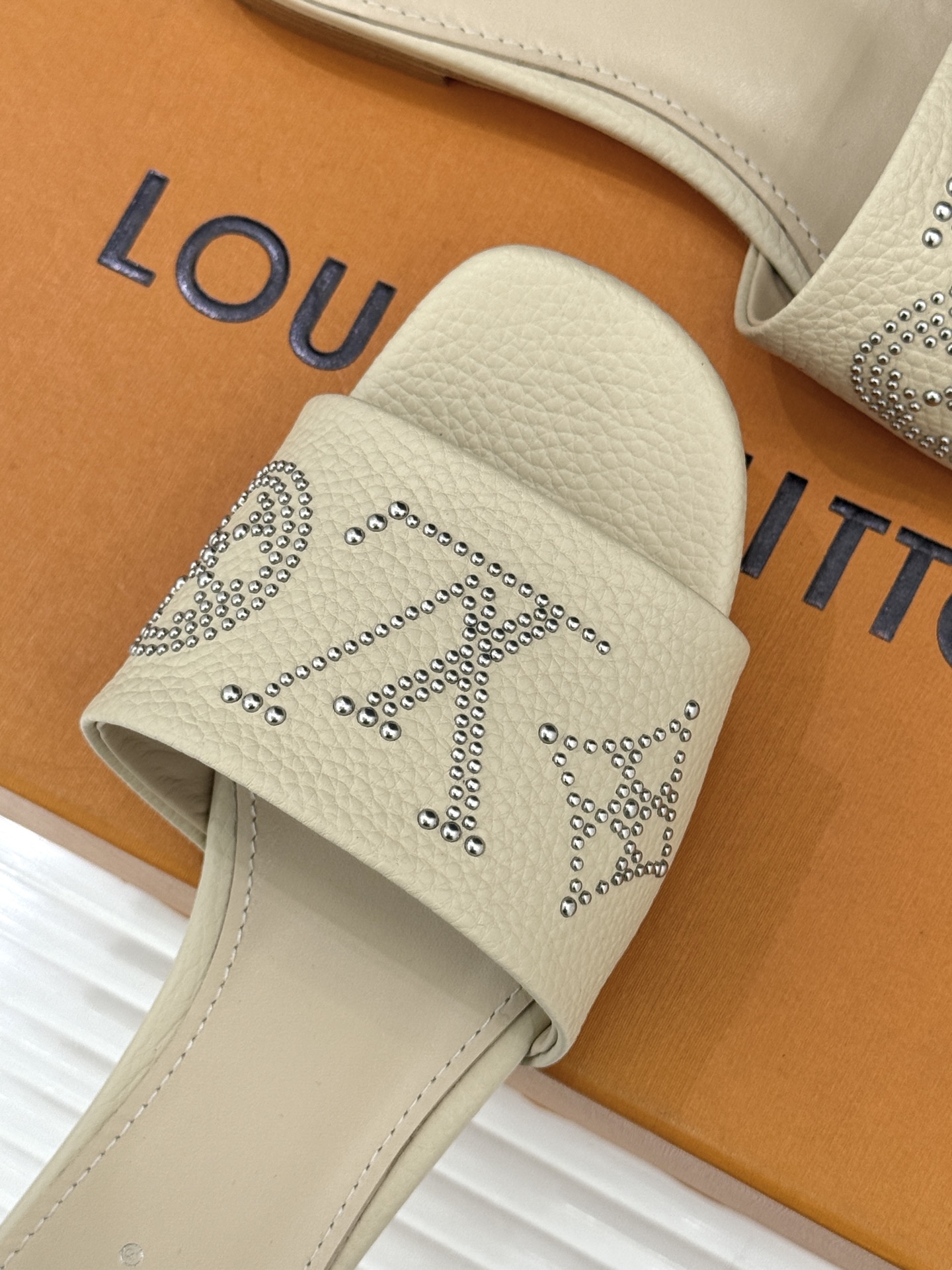 L*V驴家经典铆钉标识一字带拖鞋以极简带面勾勒足间线条金属铆钉缀以经典 Monogram 标识硬朗锋芒碰