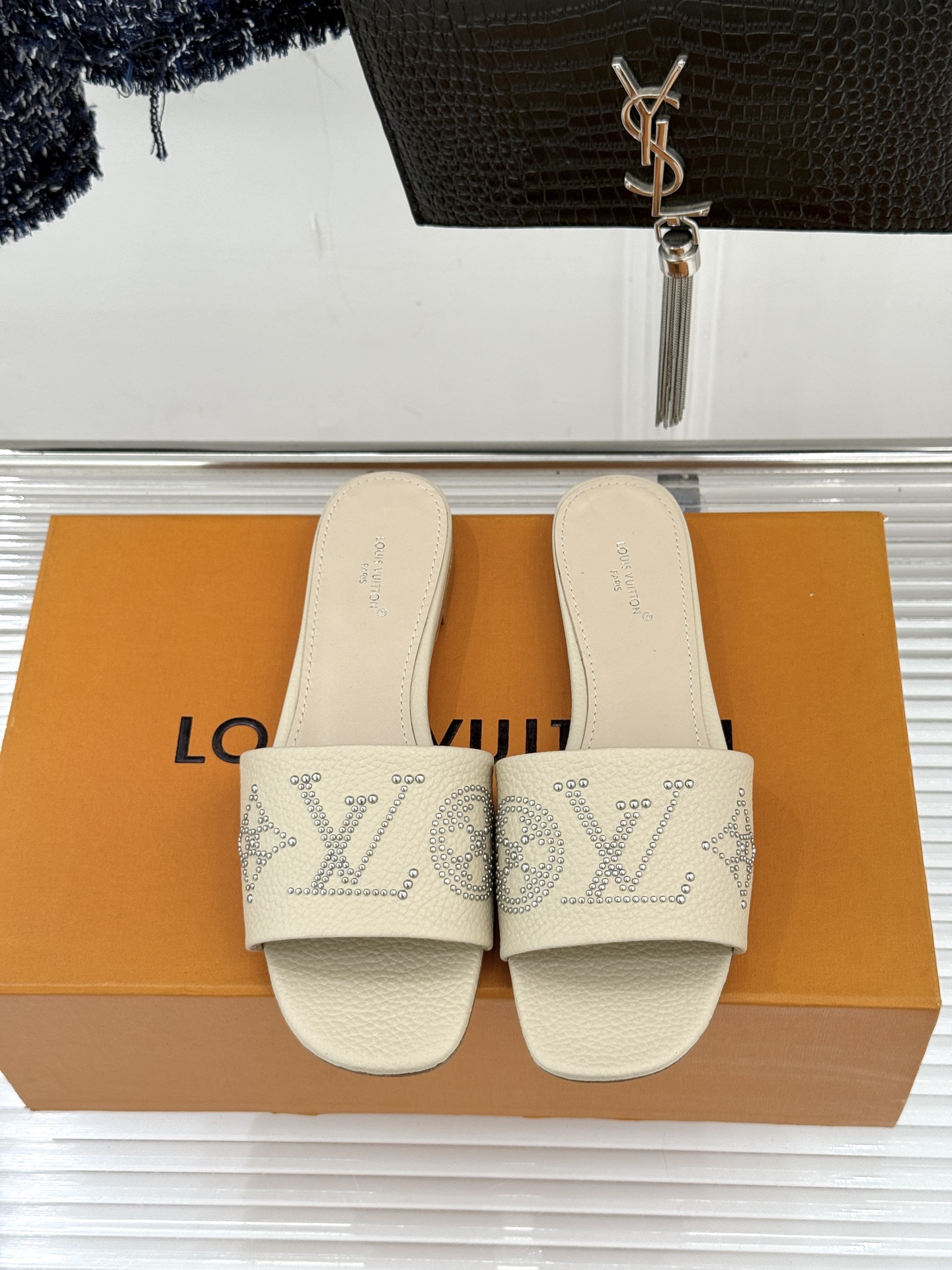 L*V驴家经典铆钉标识一字带拖鞋以极简带面勾勒足间线条金属铆钉缀以经典 Monogram 标识硬朗锋芒碰