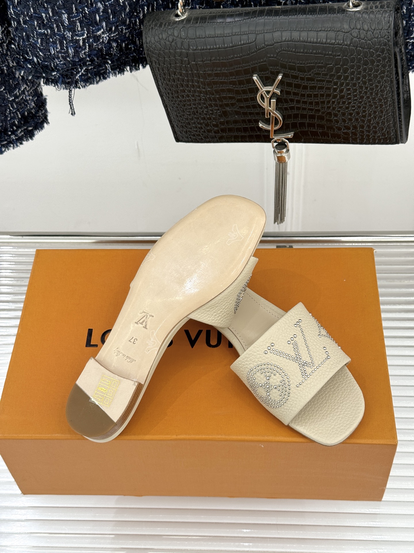 L*V驴家经典铆钉标识一字带拖鞋以极简带面勾勒足间线条金属铆钉缀以经典 Monogram 标识硬朗锋芒碰