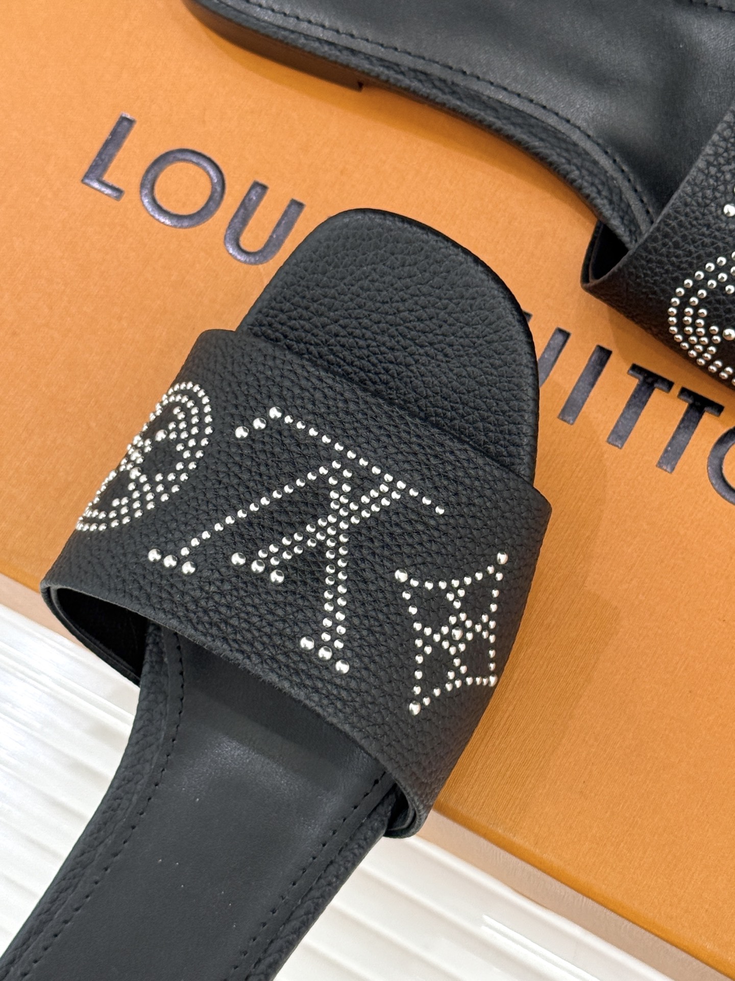 L*V驴家经典铆钉标识一字带拖鞋以极简带面勾勒足间线条金属铆钉缀以经典 Monogram 标识硬朗锋芒碰