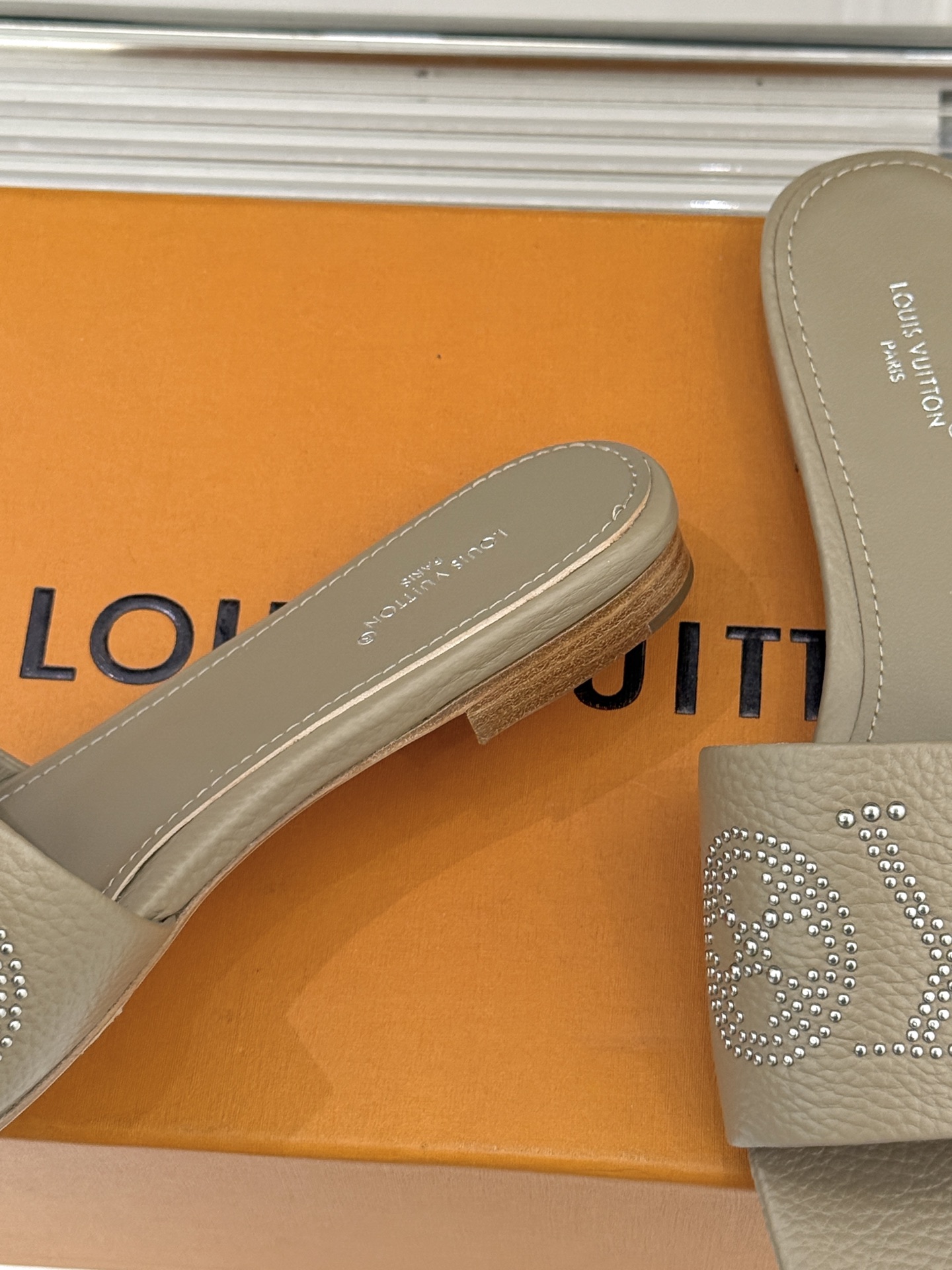 L*V驴家经典铆钉标识一字带拖鞋以极简带面勾勒足间线条金属铆钉缀以经典 Monogram 标识硬朗锋芒碰