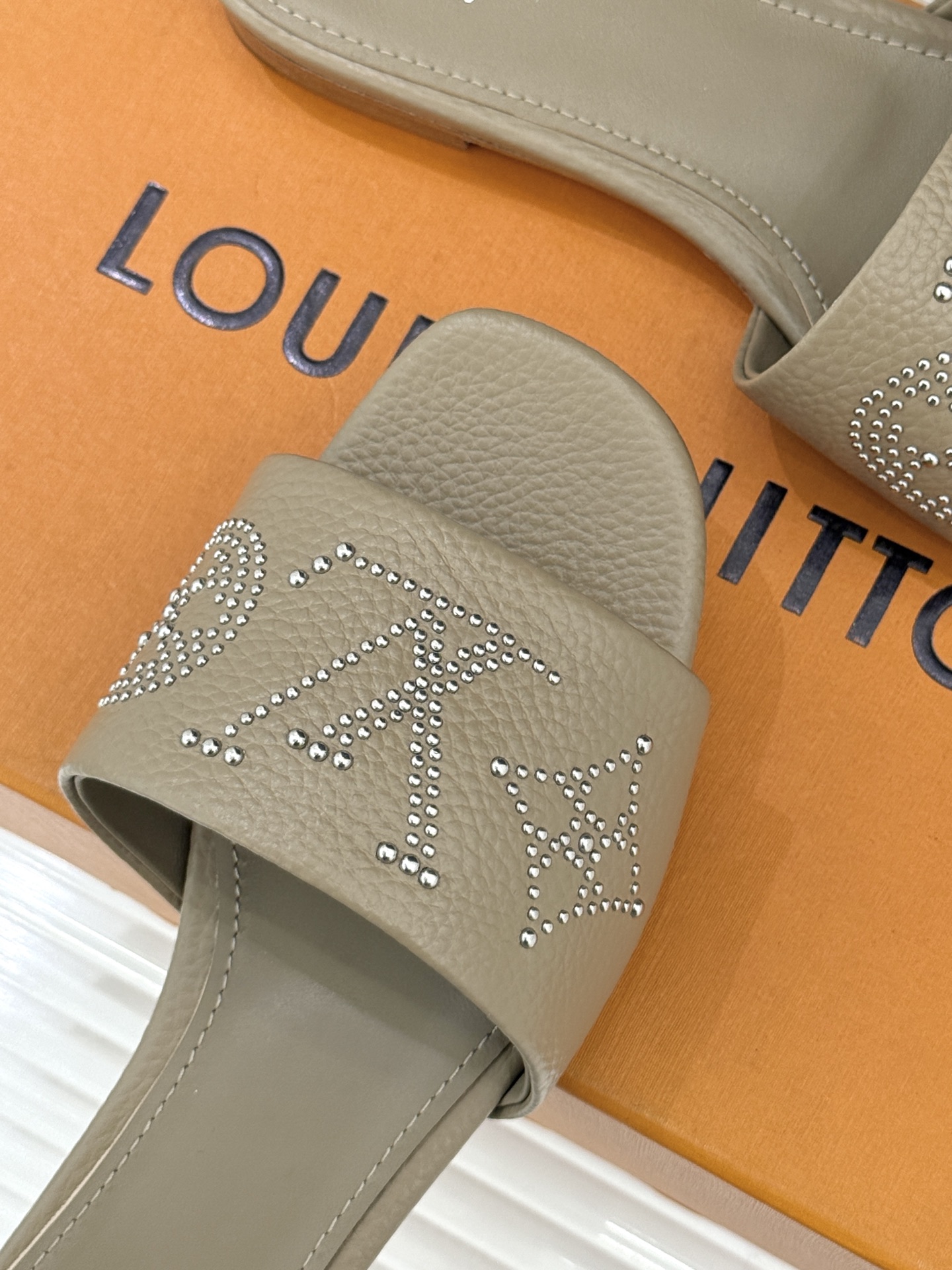 L*V驴家经典铆钉标识一字带拖鞋以极简带面勾勒足间线条金属铆钉缀以经典 Monogram 标识硬朗锋芒碰