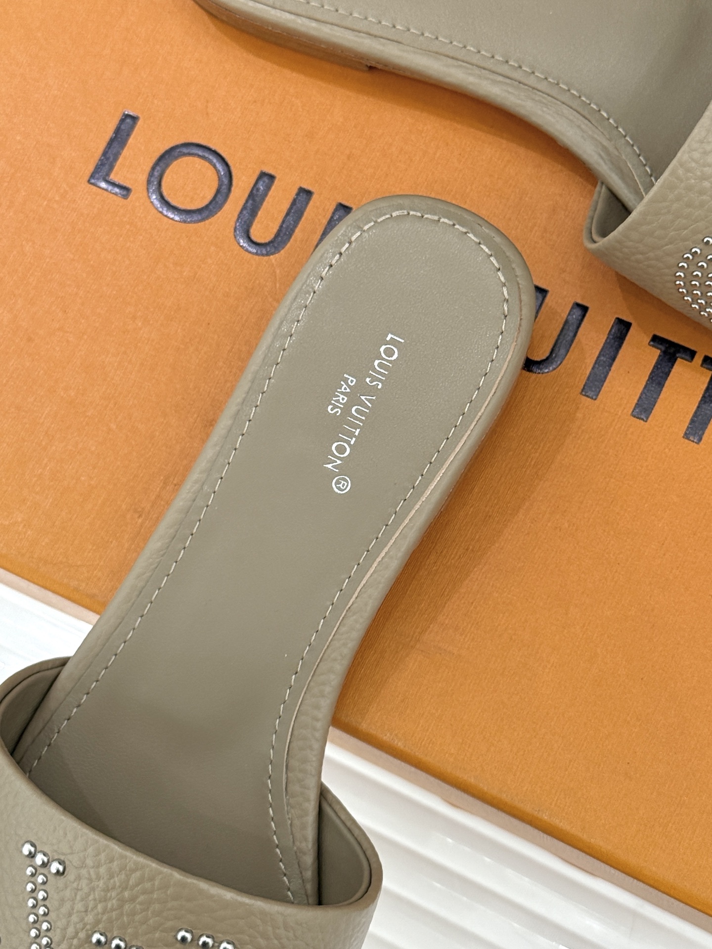 L*V驴家经典铆钉标识一字带拖鞋以极简带面勾勒足间线条金属铆钉缀以经典 Monogram 标识硬朗锋芒碰