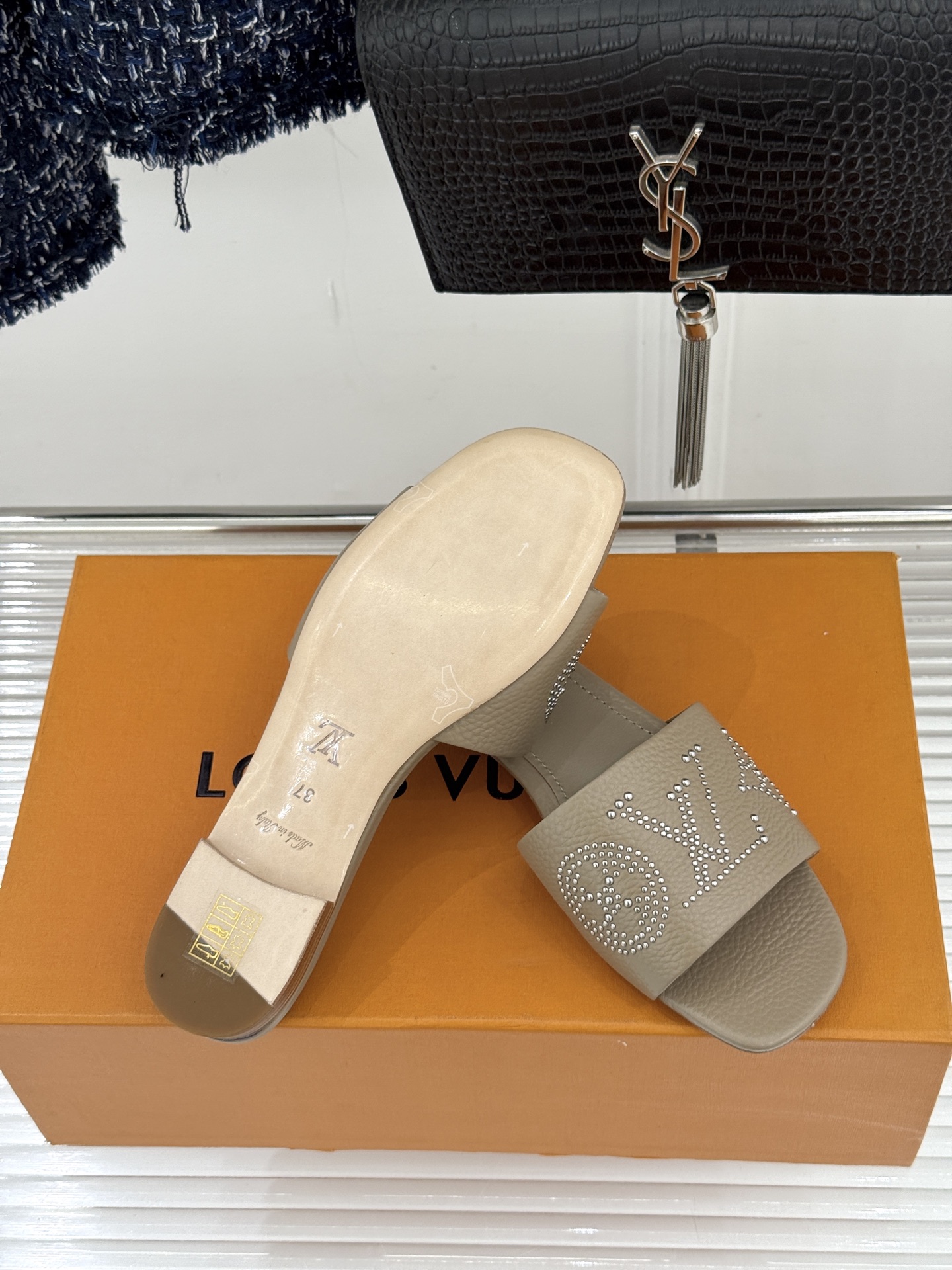 L*V驴家经典铆钉标识一字带拖鞋以极简带面勾勒足间线条金属铆钉缀以经典 Monogram 标识硬朗锋芒碰