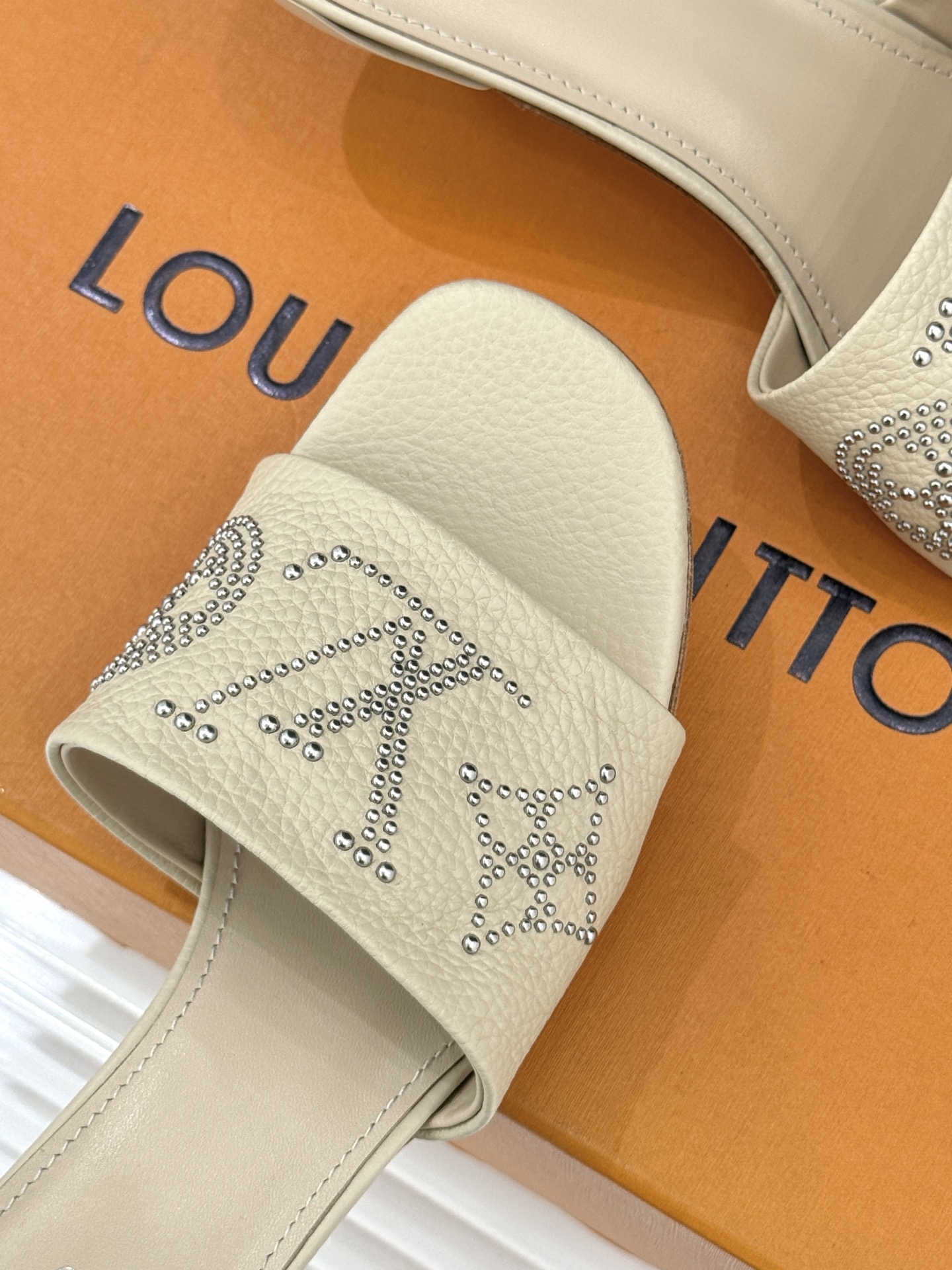 L*V驴家经典铆钉标识一字带拖鞋以极简带面勾勒足间线条金属铆钉缀以经典 Monogram 标识硬朗锋芒碰