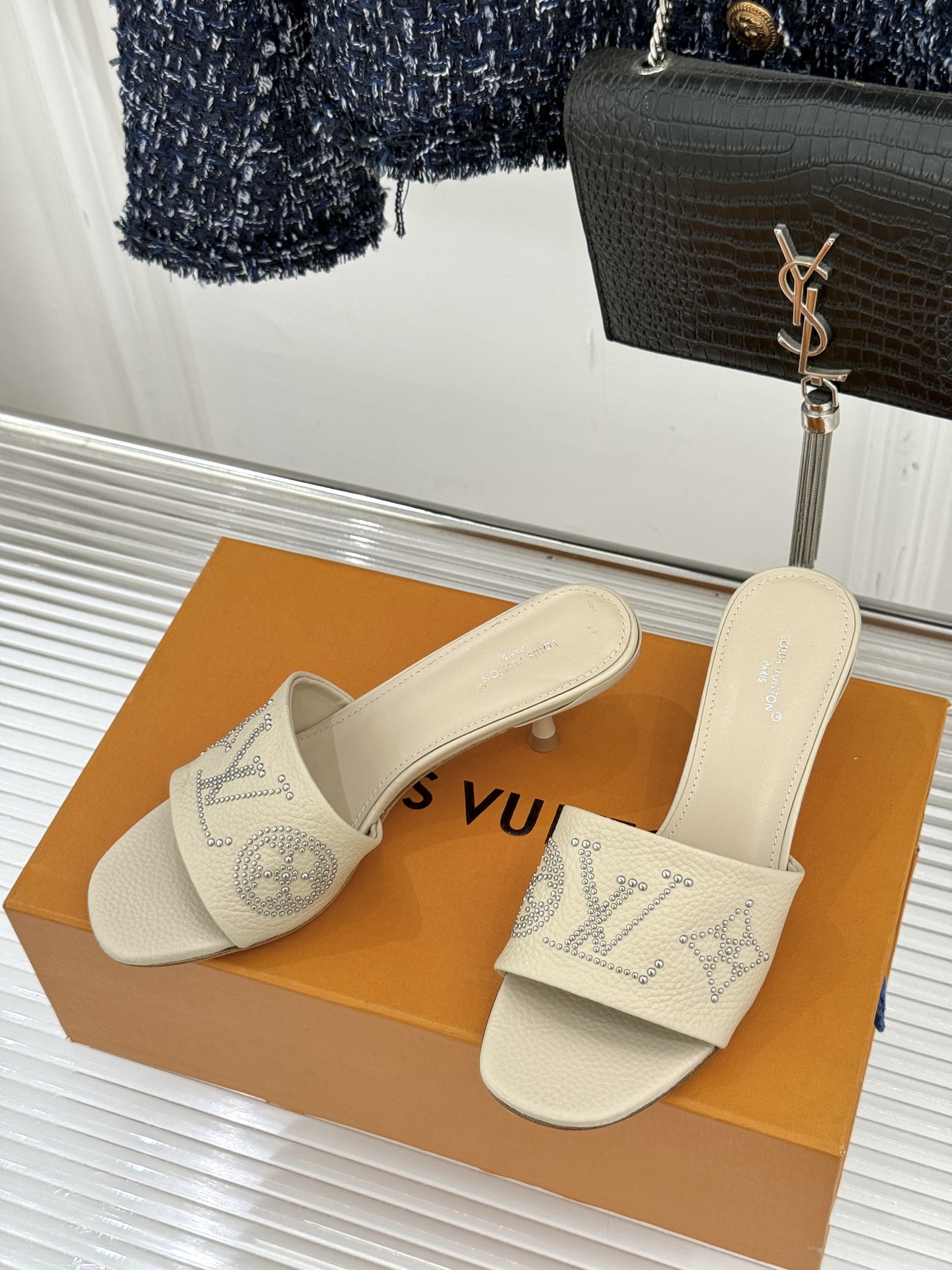 L*V驴家经典铆钉标识一字带拖鞋以极简带面勾勒足间线条金属铆钉缀以经典 Monogram 标识硬朗锋芒碰