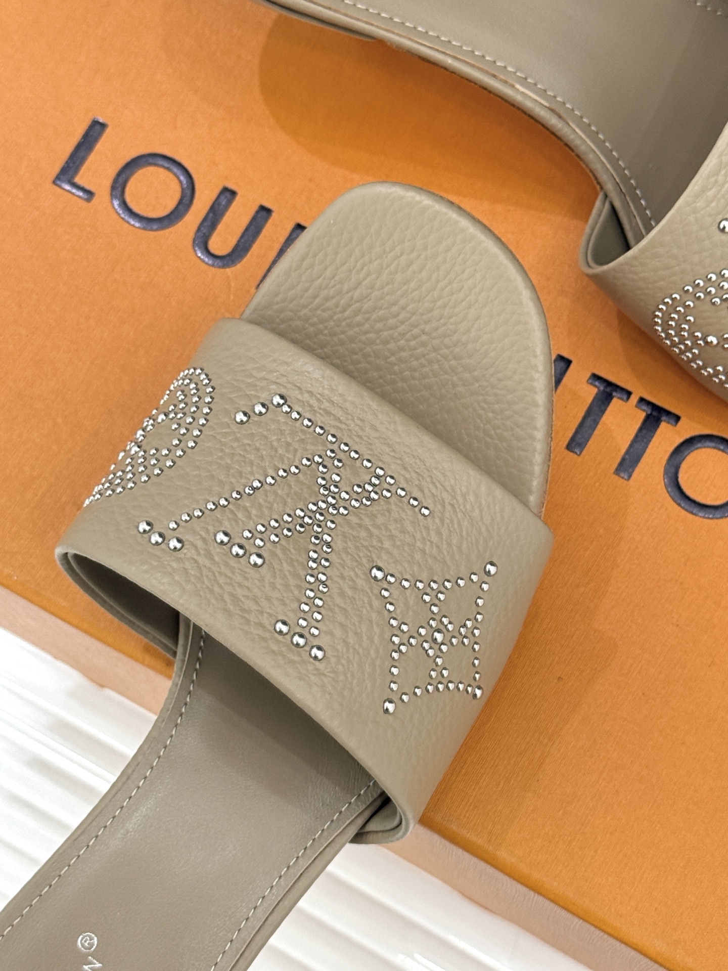 L*V驴家经典铆钉标识一字带拖鞋以极简带面勾勒足间线条金属铆钉缀以经典 Monogram 标识硬朗锋芒碰