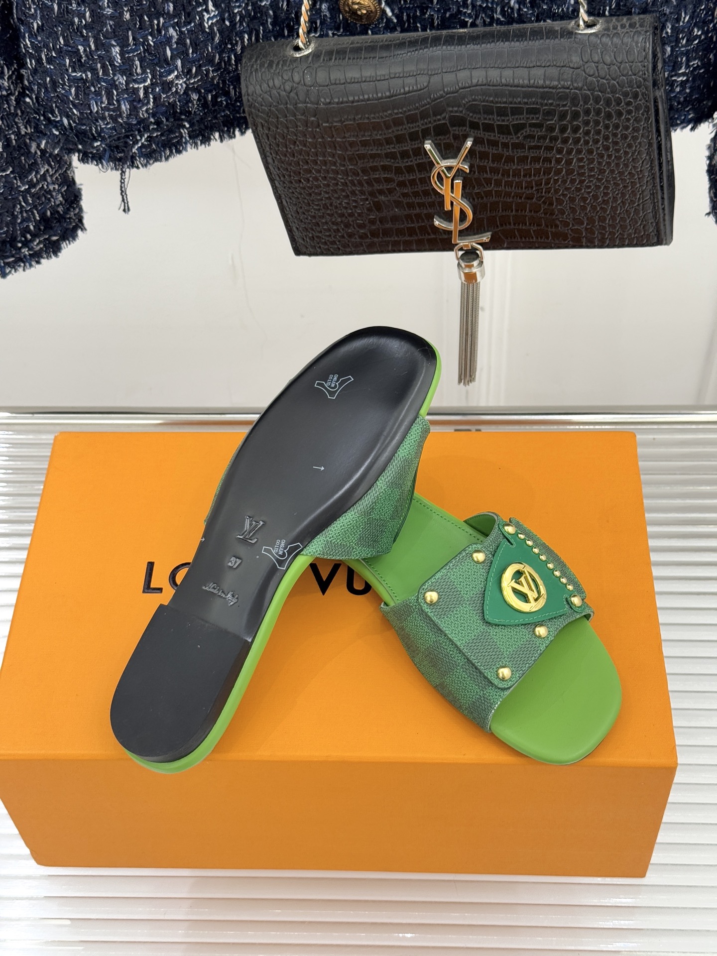 L*V驴家经典老花金属扣平底拖鞋以标志性老花皮革勾勒优雅轮廓意大利匠心工艺凝萃百年奢韵。亮眼金色金属扣镌