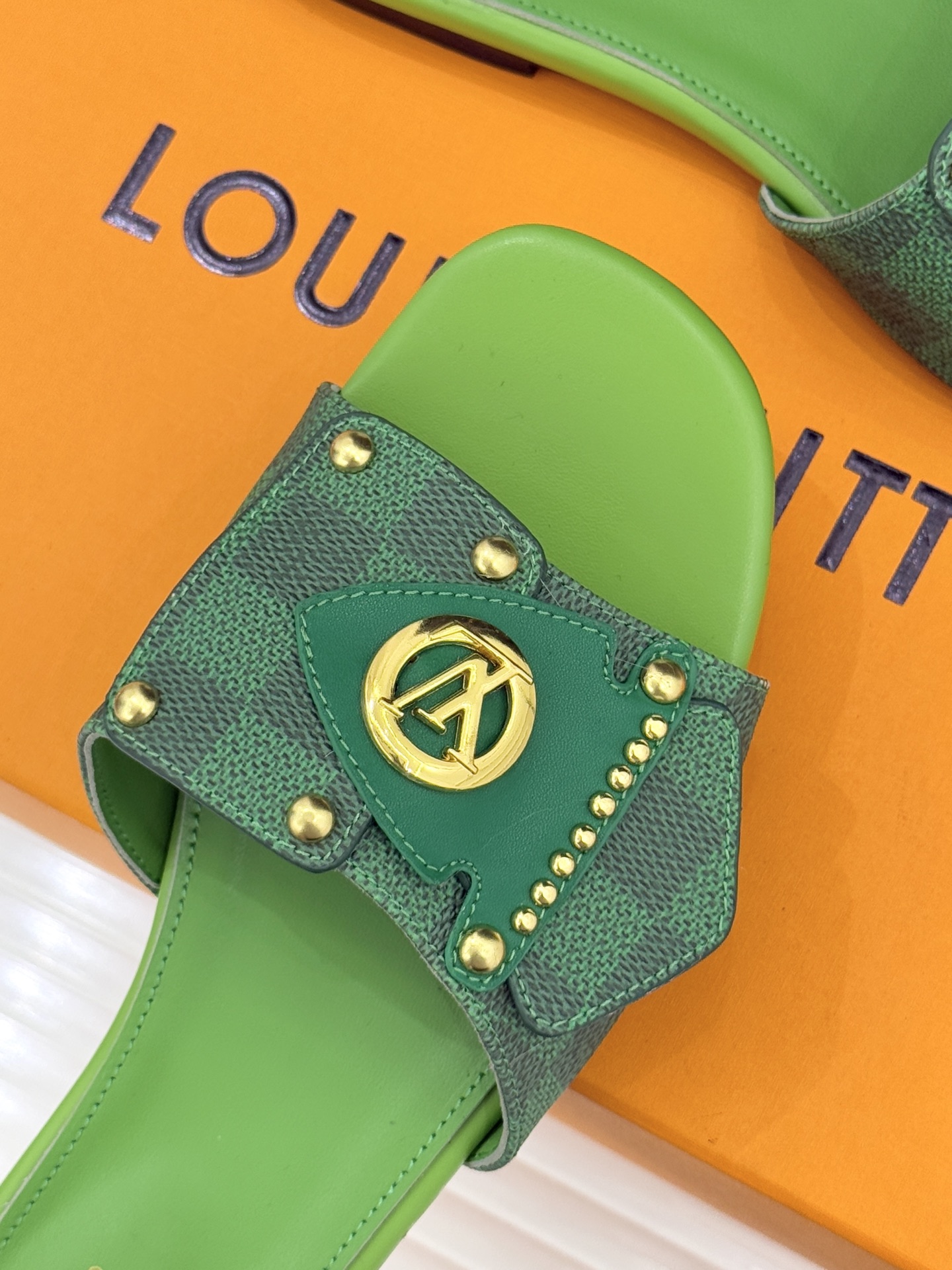 L*V驴家经典老花金属扣平底拖鞋以标志性老花皮革勾勒优雅轮廓意大利匠心工艺凝萃百年奢韵。亮眼金色金属扣镌