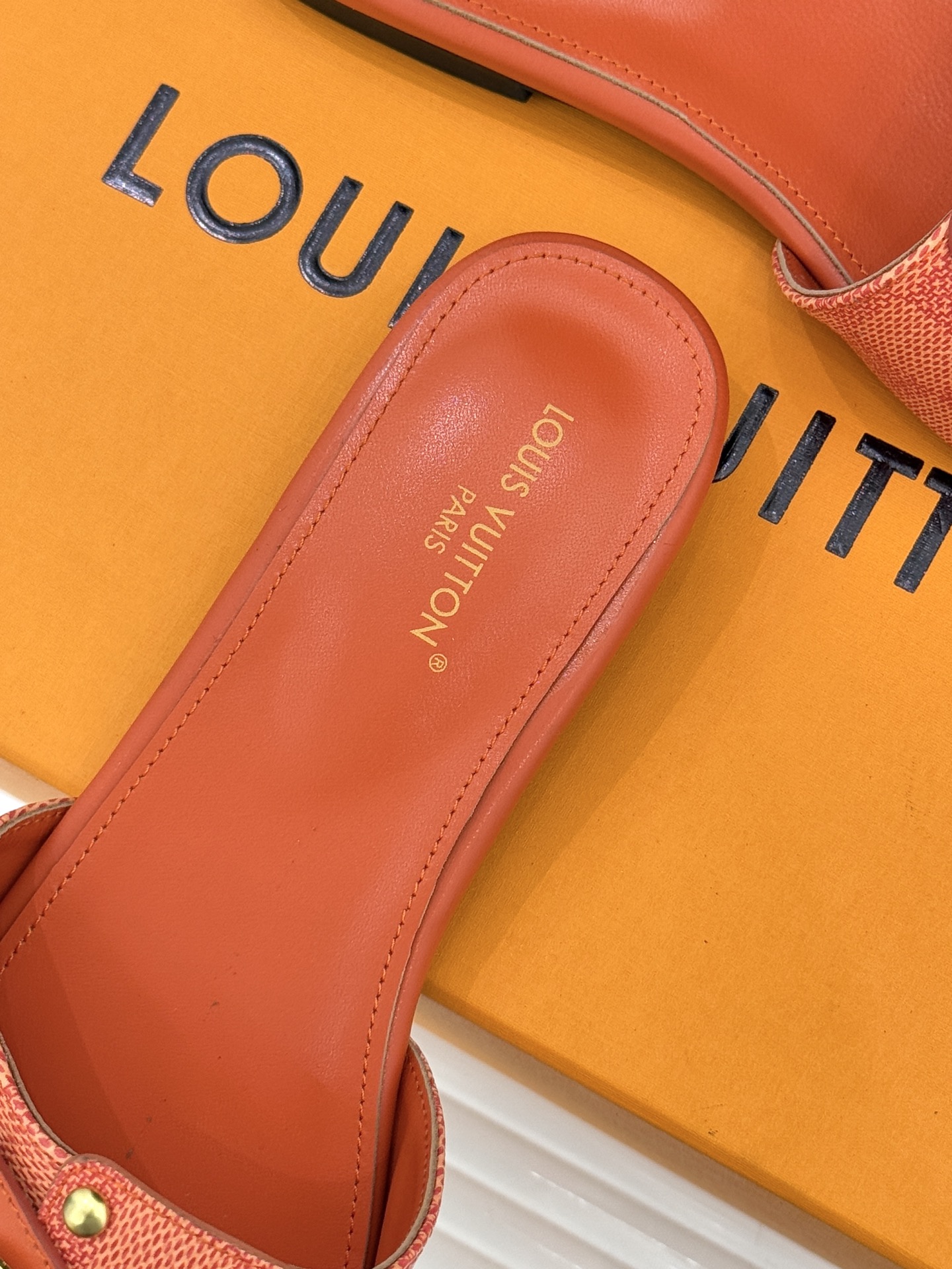 L*V驴家经典老花金属扣平底拖鞋以标志性老花皮革勾勒优雅轮廓意大利匠心工艺凝萃百年奢韵。亮眼金色金属扣镌