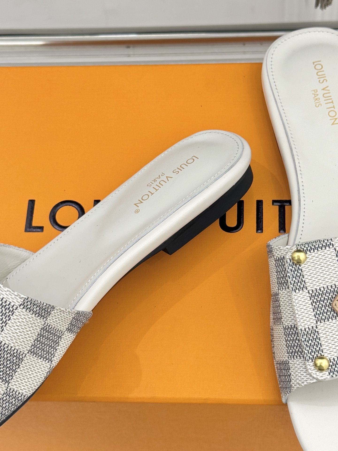 L*V驴家经典老花金属扣平底拖鞋以标志性老花皮革勾勒优雅轮廓意大利匠心工艺凝萃百年奢韵。亮眼金色金属扣镌