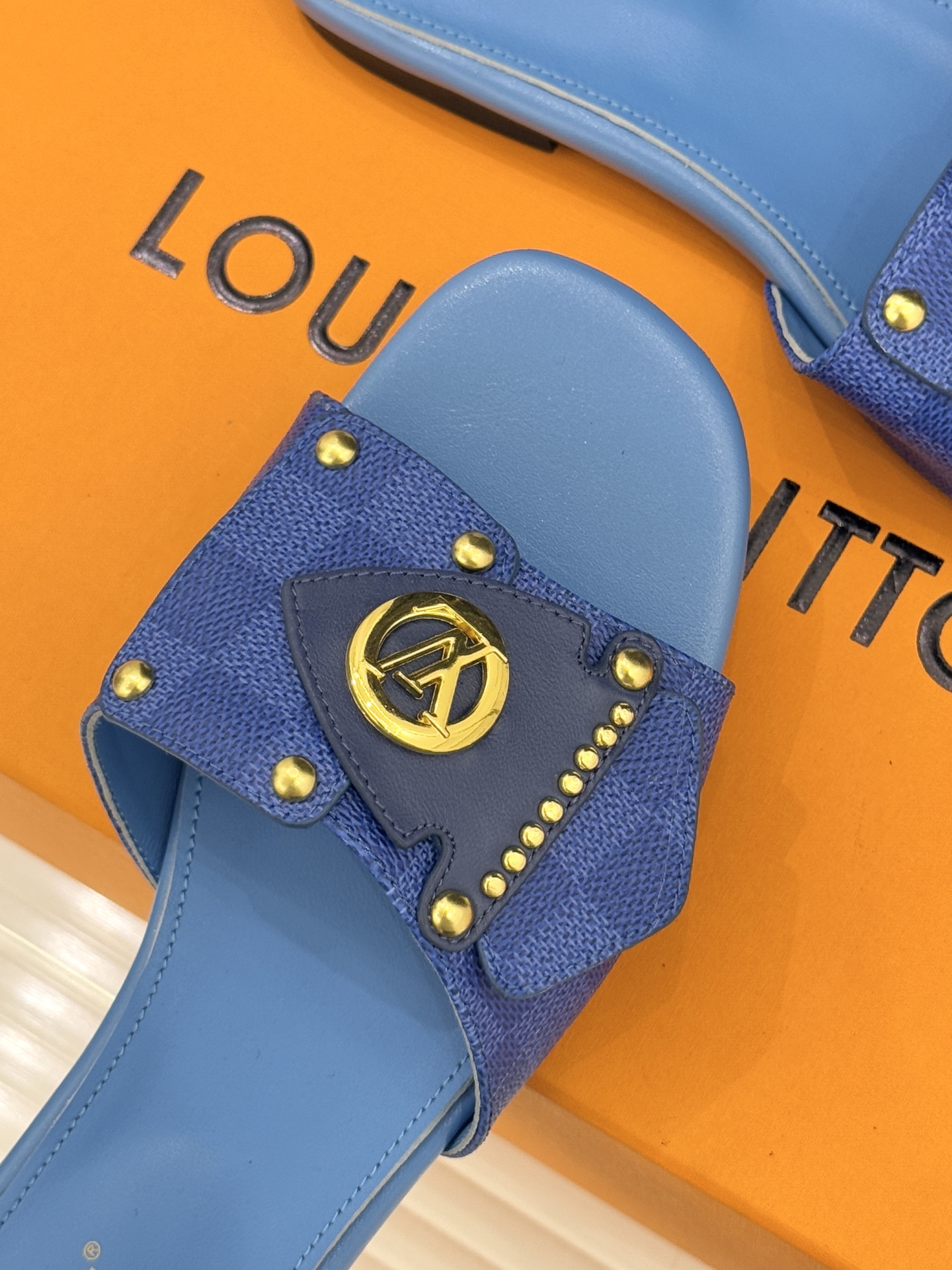 L*V驴家经典老花金属扣平底拖鞋以标志性老花皮革勾勒优雅轮廓意大利匠心工艺凝萃百年奢韵。亮眼金色金属扣镌