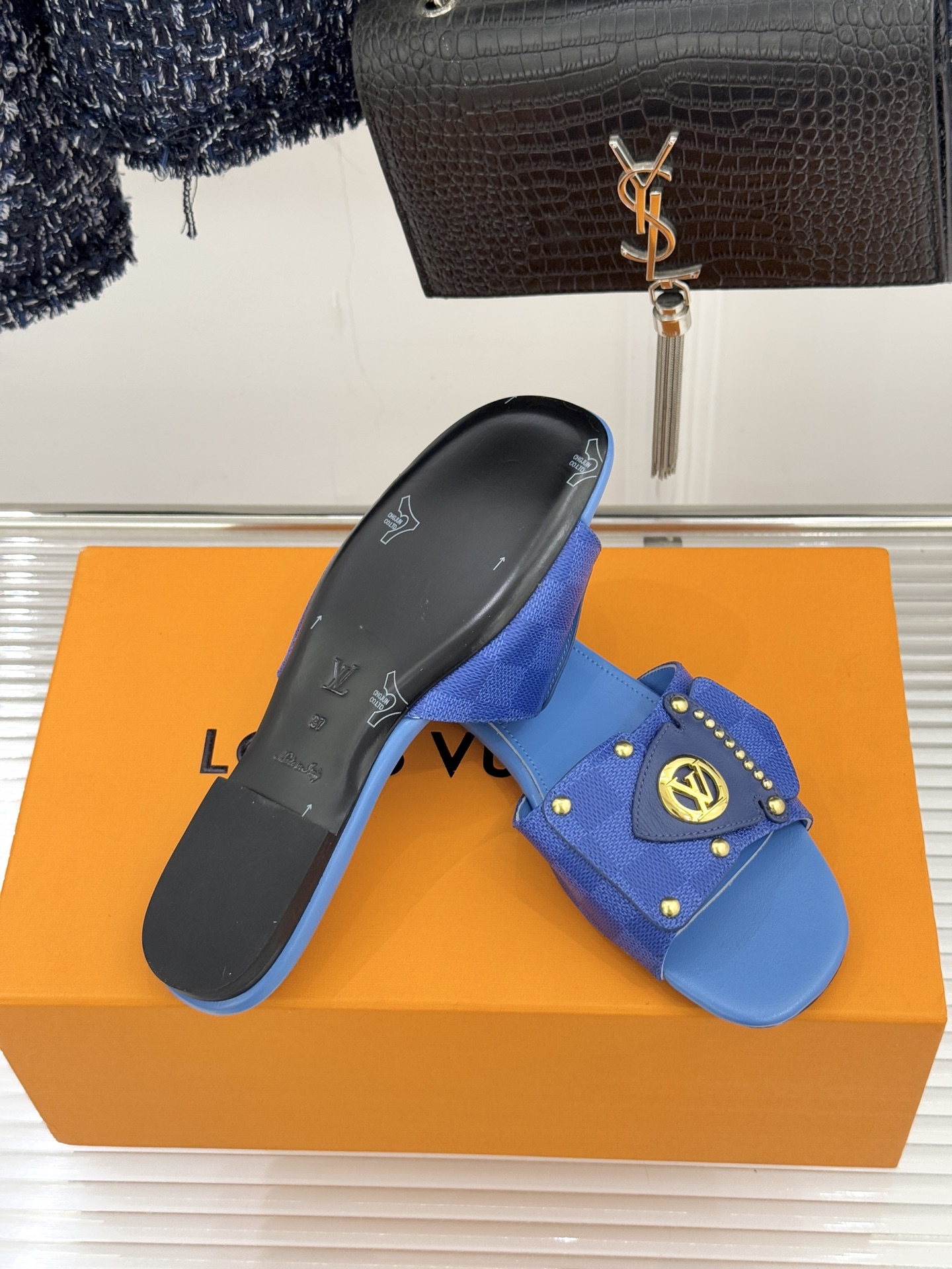 L*V驴家经典老花金属扣平底拖鞋以标志性老花皮革勾勒优雅轮廓意大利匠心工艺凝萃百年奢韵。亮眼金色金属扣镌