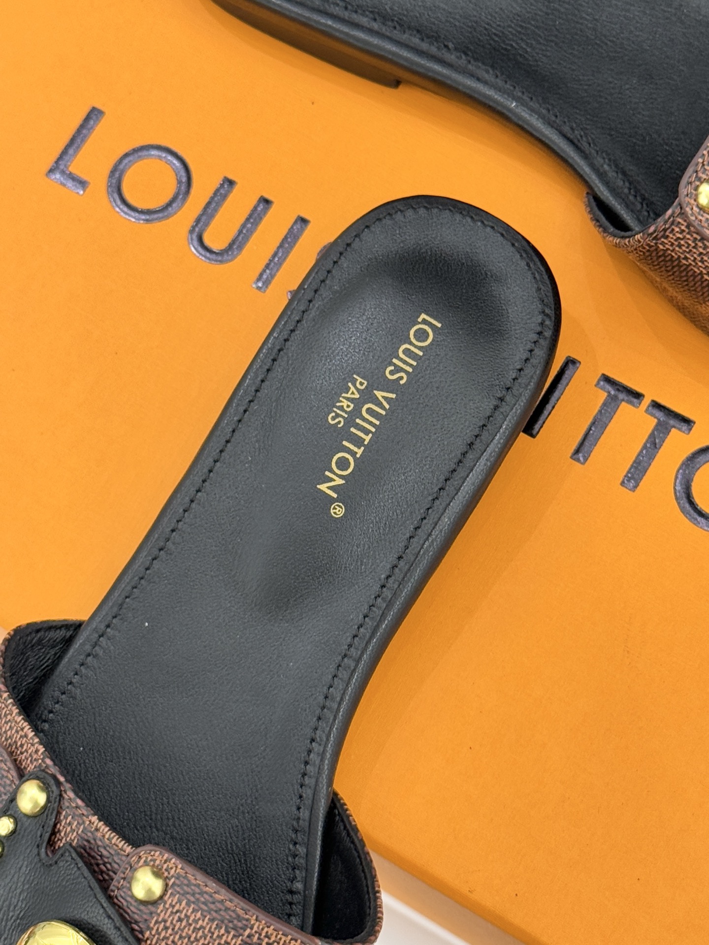 L*V驴家经典老花金属扣平底拖鞋以标志性老花皮革勾勒优雅轮廓意大利匠心工艺凝萃百年奢韵。亮眼金色金属扣镌