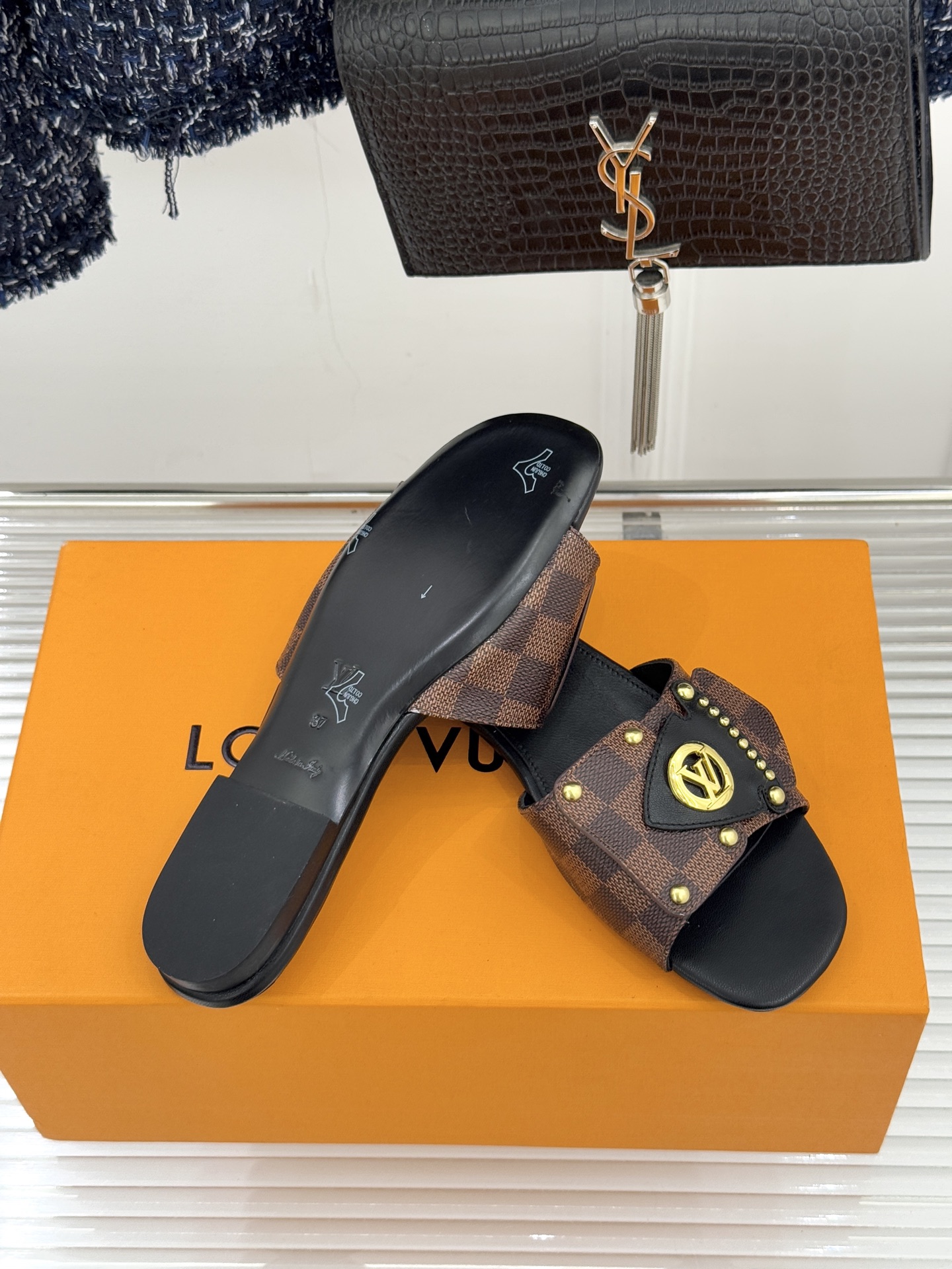 L*V驴家经典老花金属扣平底拖鞋以标志性老花皮革勾勒优雅轮廓意大利匠心工艺凝萃百年奢韵。亮眼金色金属扣镌